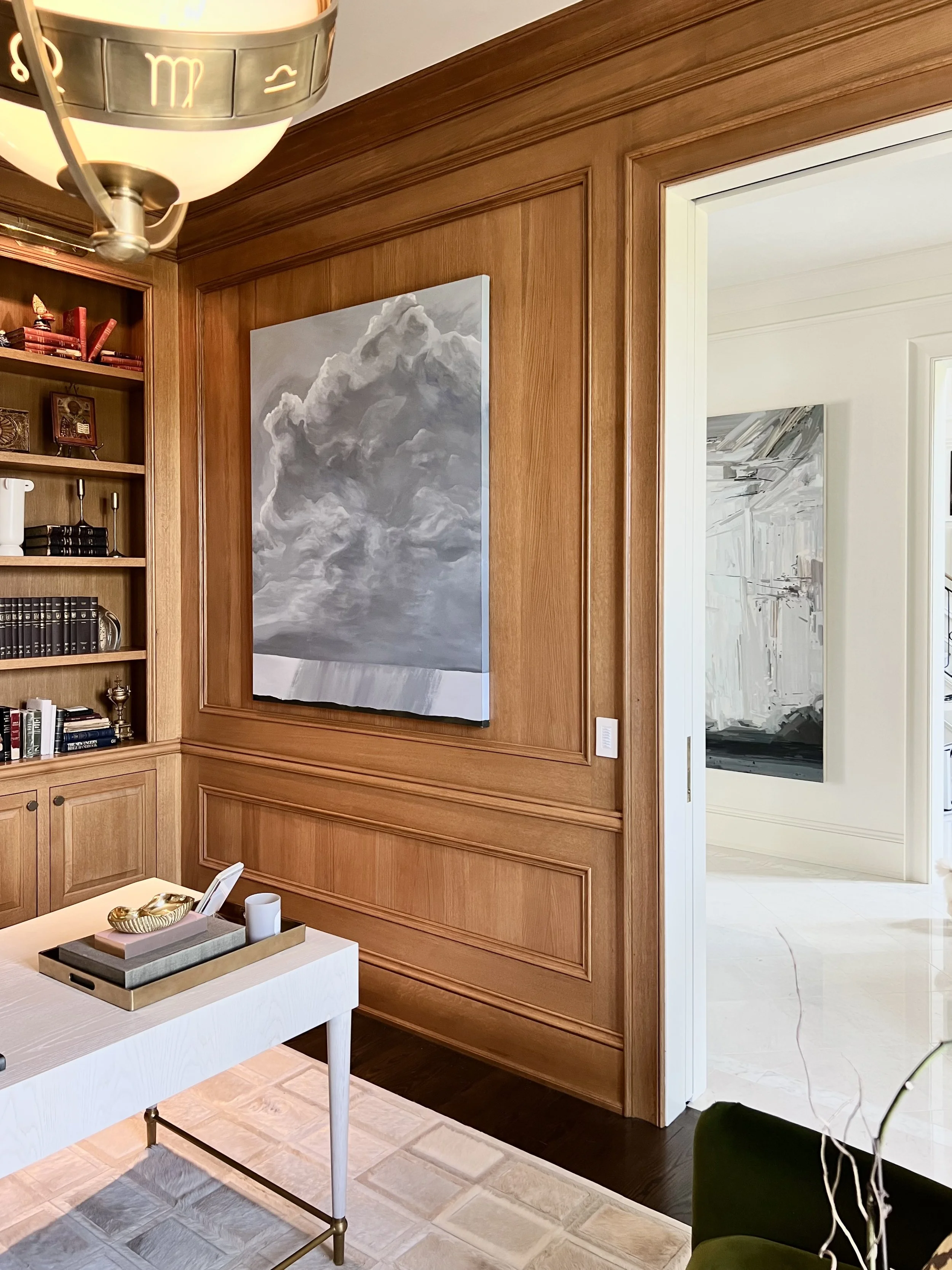 Light wood paneled office with bold contemporary painting by RF Alvarez, a Claire Sherman in the entry is visible.