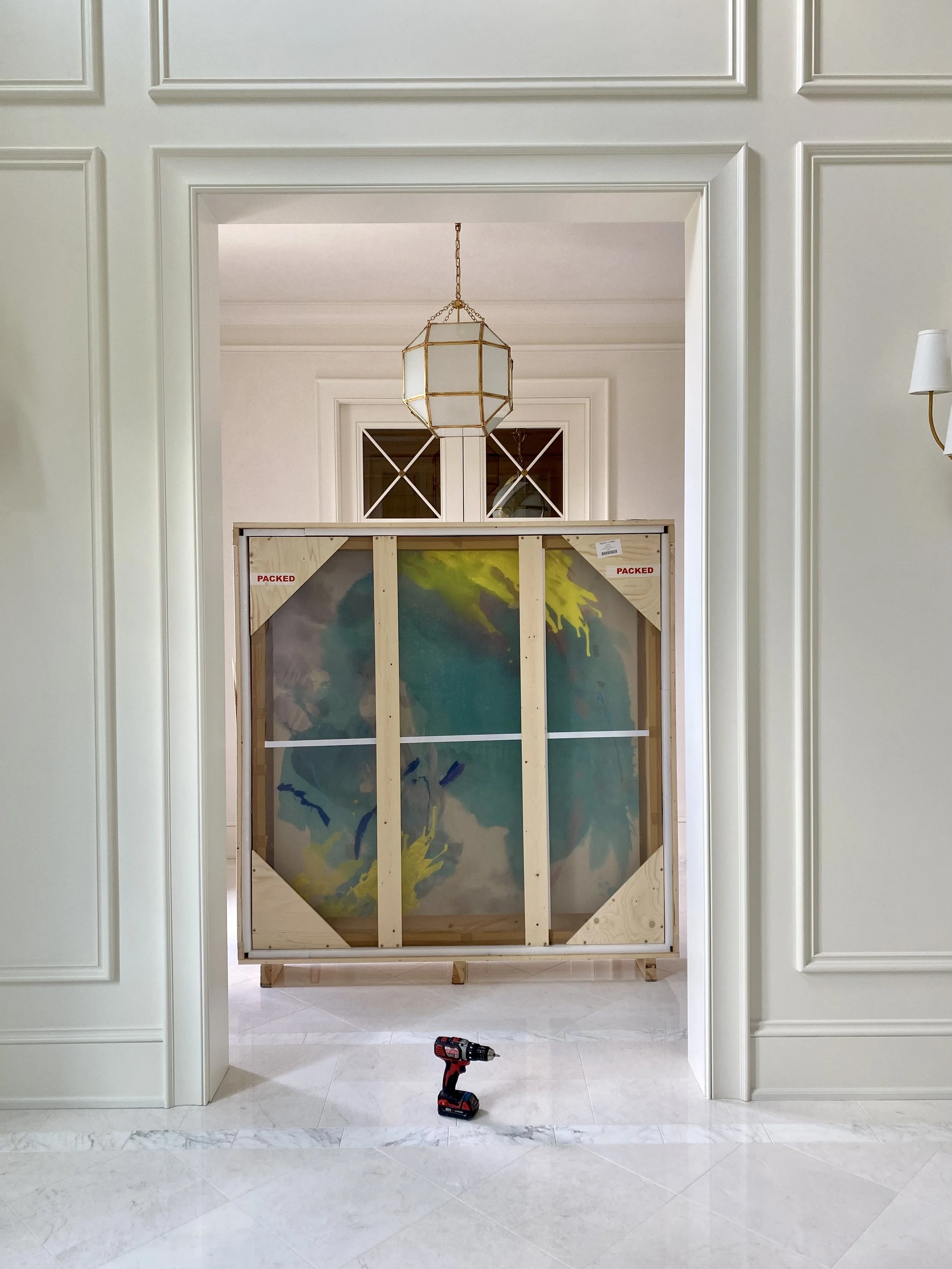 A Jessica Rankin painting in a crate during the installation process at a  private collectors large traditional mansion.  Designed by Dylan Turk
