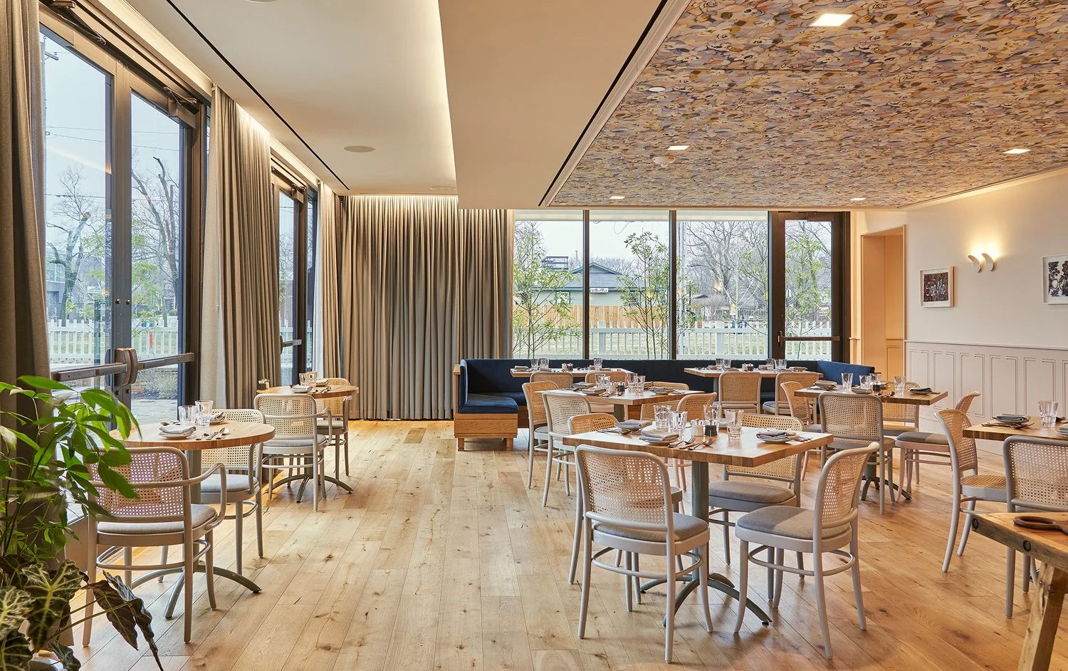 The dining room, with Voutsa wallpaper on the ceiling, Ebony Patterson works lining the walls, and an intimate comfortable main dining room. Dylan Turk.