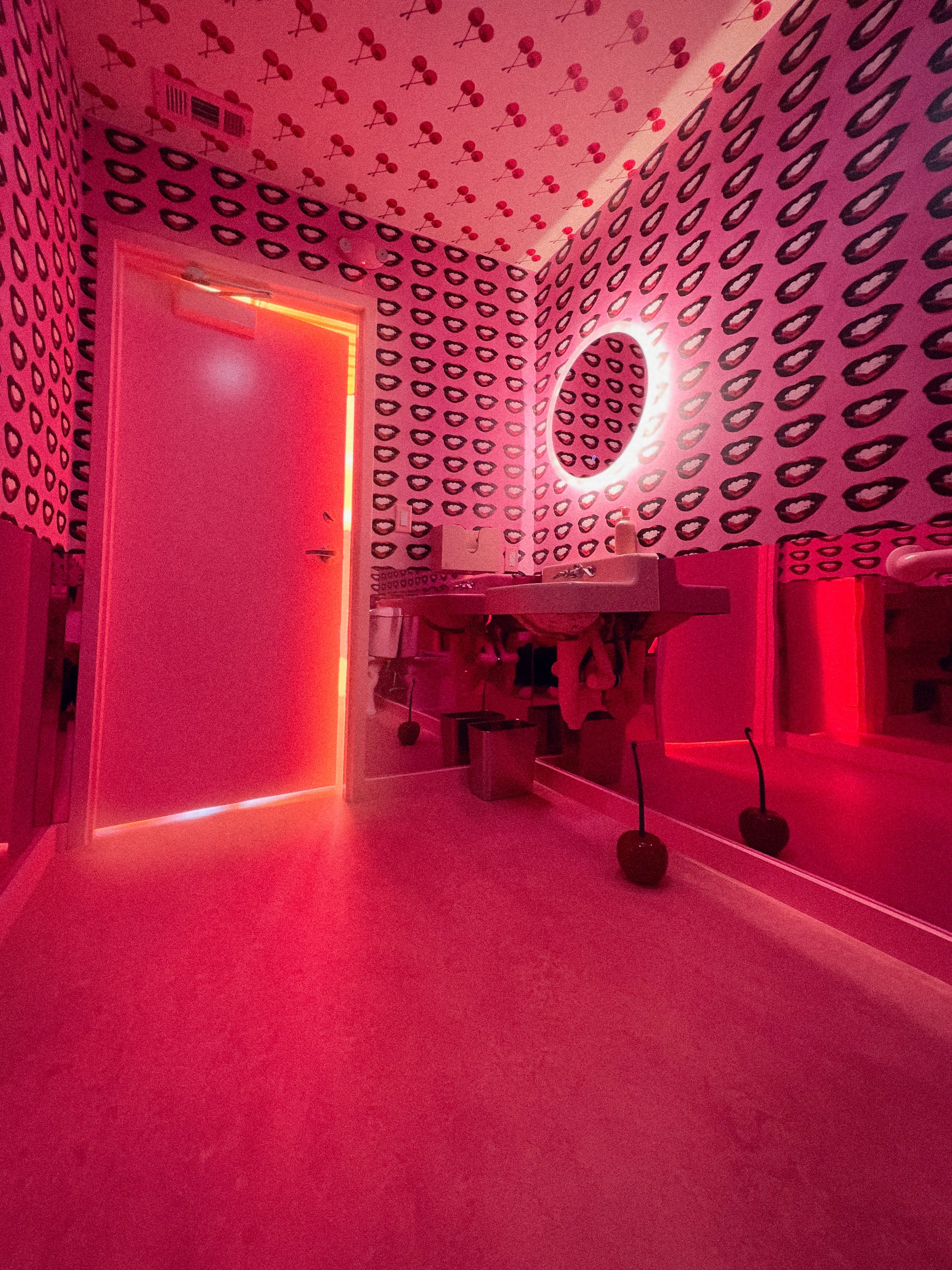 Bold, pink, wallpapered bathroom at superfine designed by Dylan Turk. Flavor Paper wallpaper is the dominate factor in this hospitality bathroom.