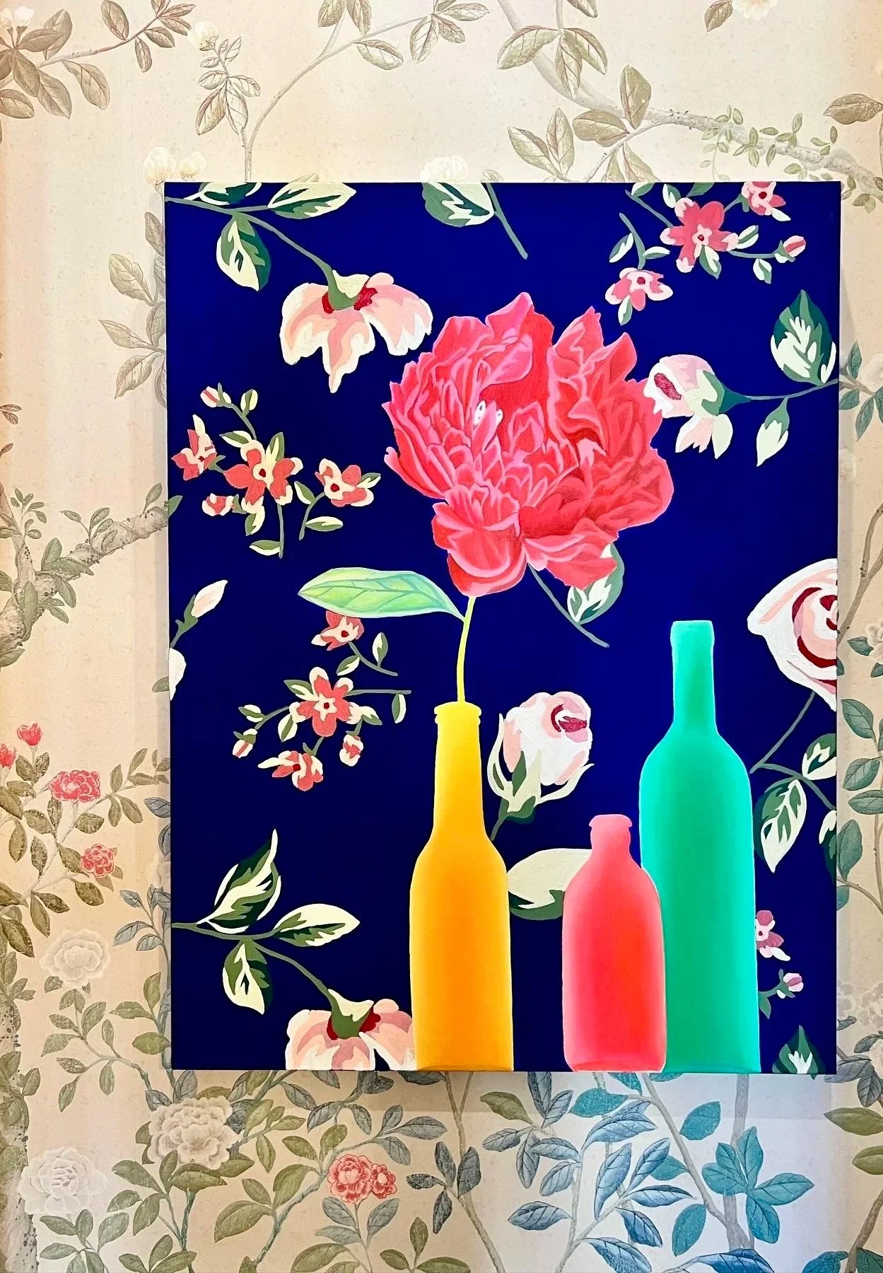 Colorful painting by Los Angeles Painter Alec Egan against traditional floral wallpaper in a bathroom.