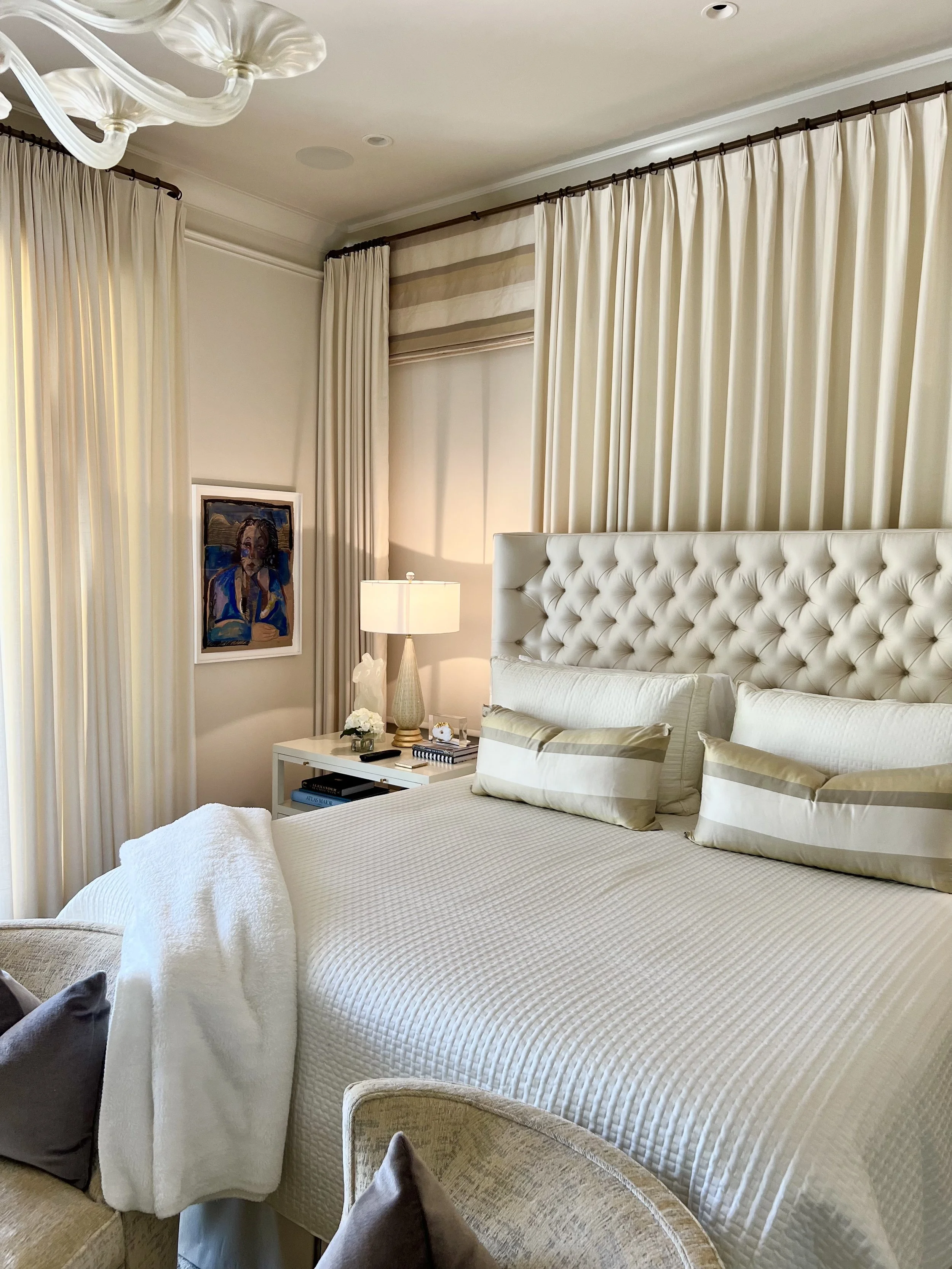 A creamy luscious primary bedroom with a bold, French inspired painting by Kate Barbee.