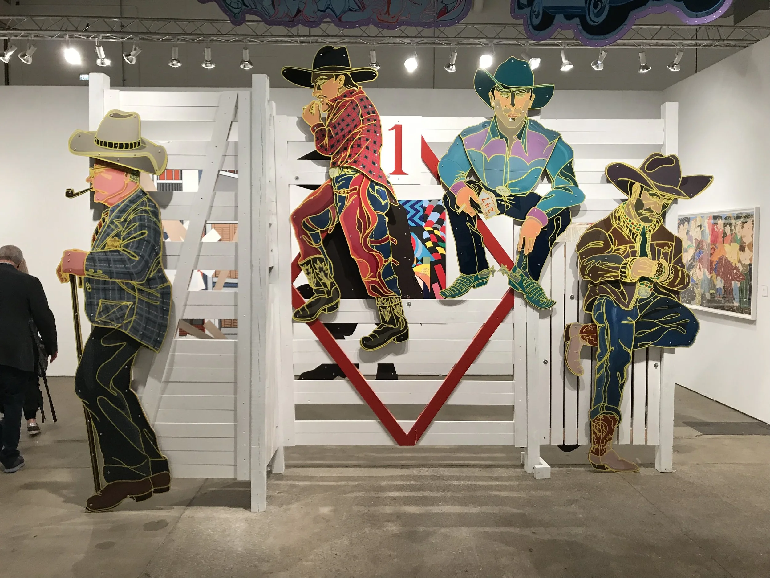 Colorful artwork of four cowboy figures with hats, boots, and a pipe, standing against a white wooden background with a red diamond shape and the number 1 in the center.