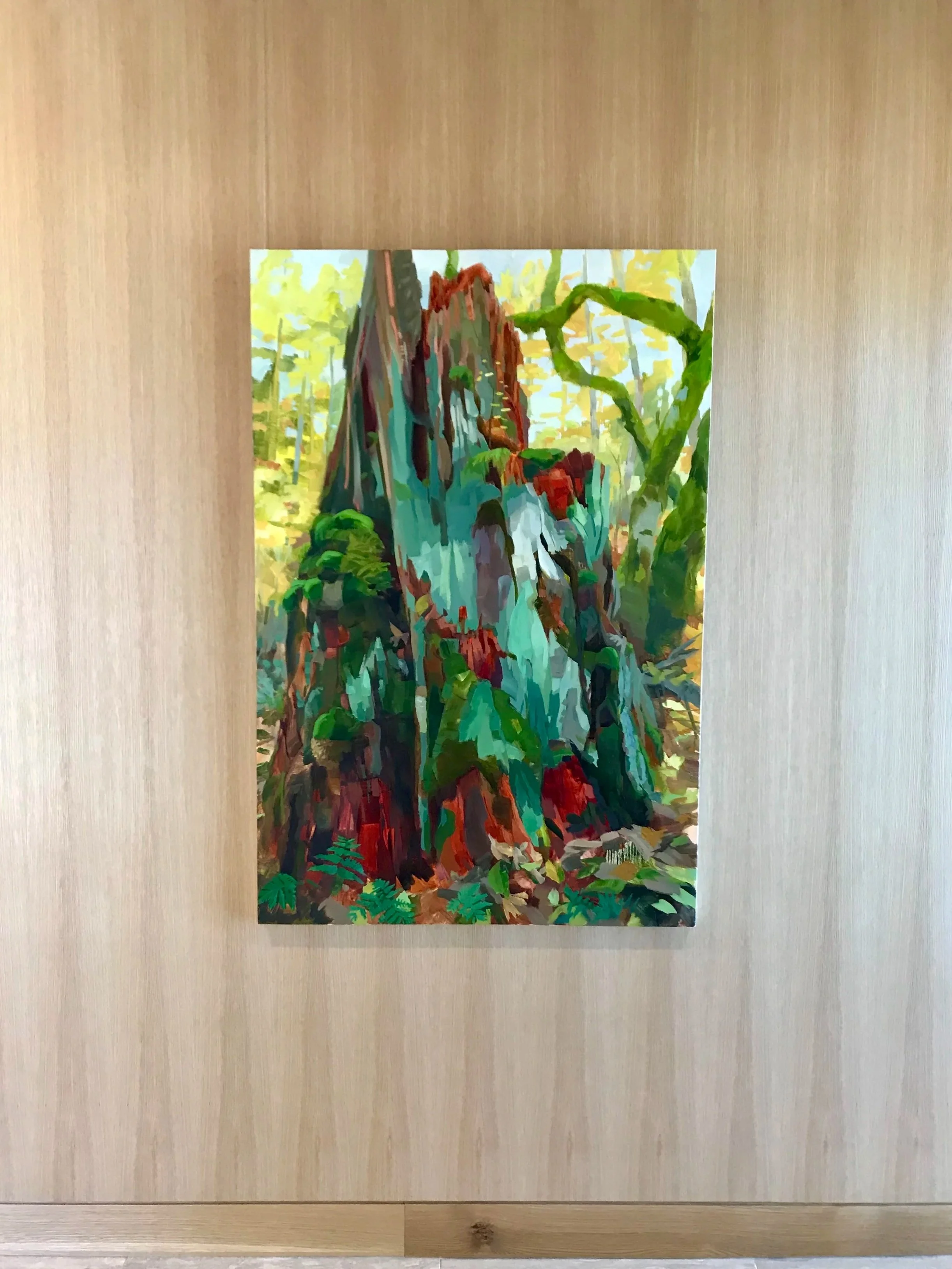 A colorful painting of a totem pole in a forest with lush greenery and tall trees.