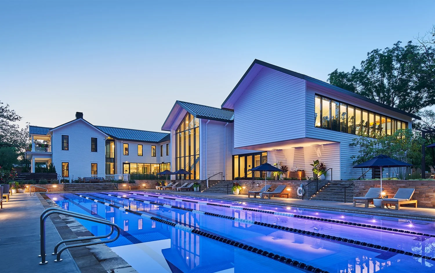 The illuminated night shot of the pool and building of Blake Street House member club. The art collection curated by former Crystal Bridges Museum curator Dylan Turk.