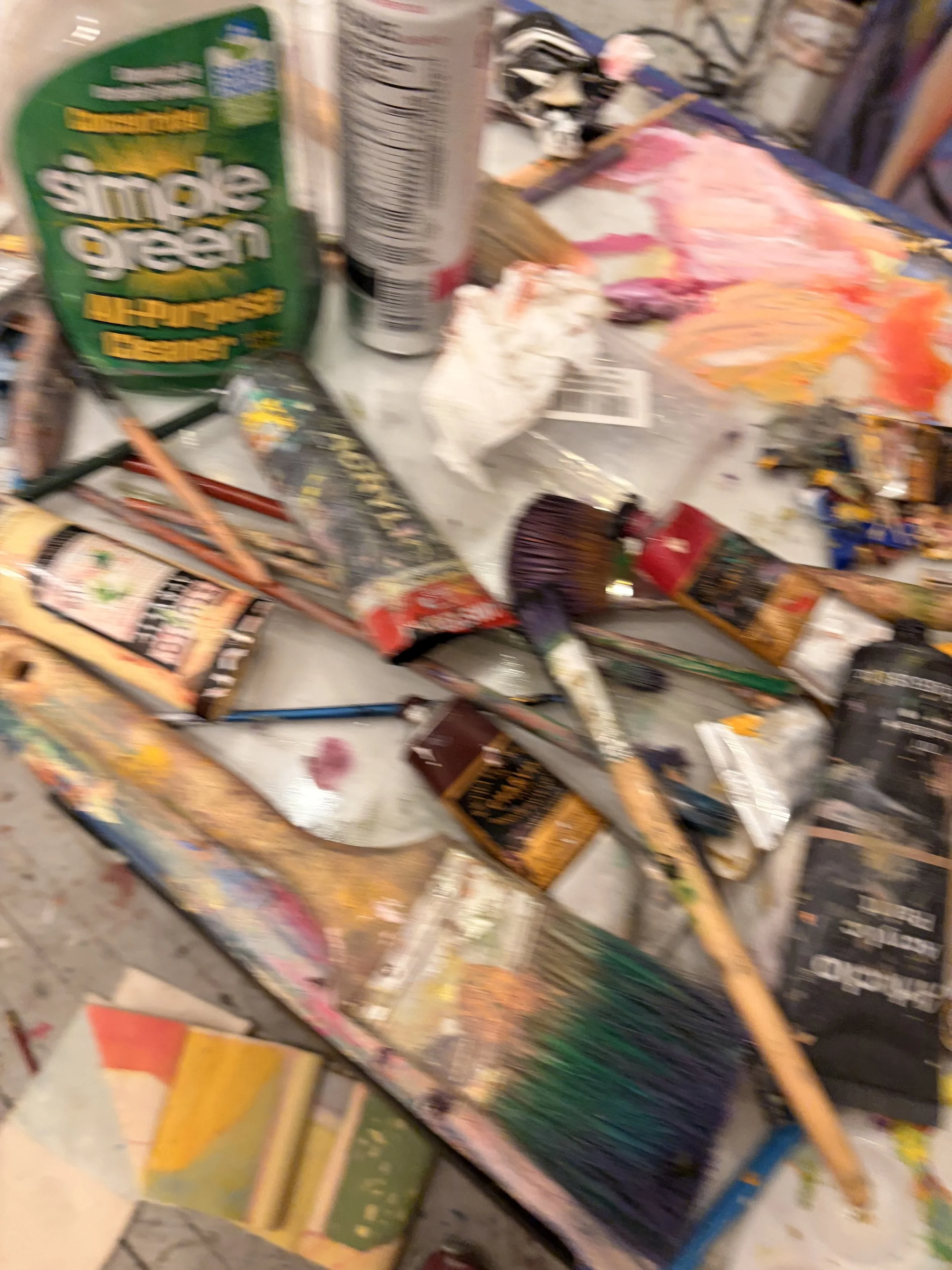 Blurred photo of various fireworks and firework boxes on a surface.
