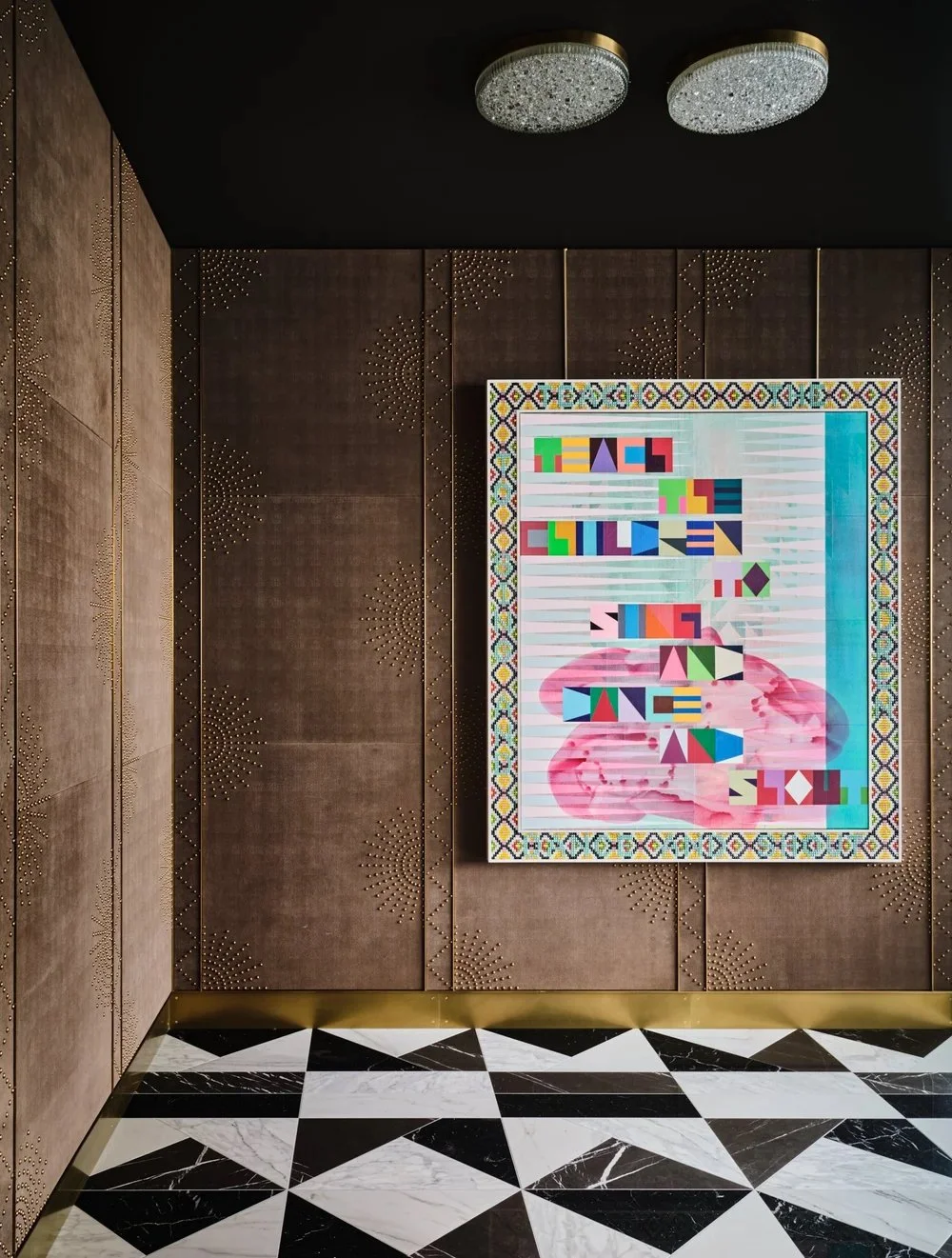 A luxurious, black and white marble floor, leather studded walls, Jeffrey Gibson painting on the wall. An Austin, Texas penthouse designed by Fern Santini, art collection curated by Dylan Turk. Leading Austin designers.