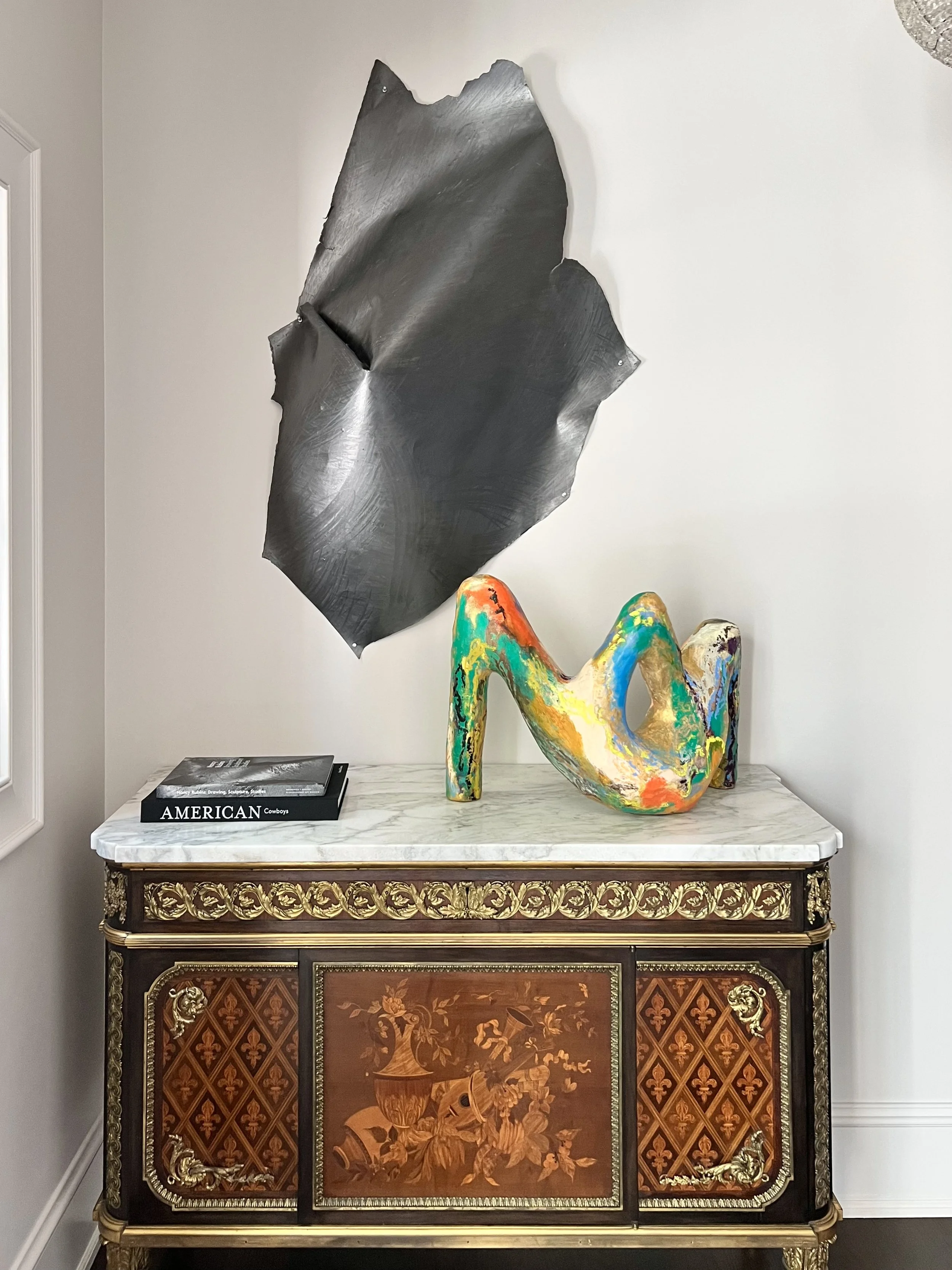 Historic French antique with a Nancy Rubins wall drawing above it, dark wood floors, traditional millwork and a contemporary sculpture on the chest in this luxurious contemporary traditional home.