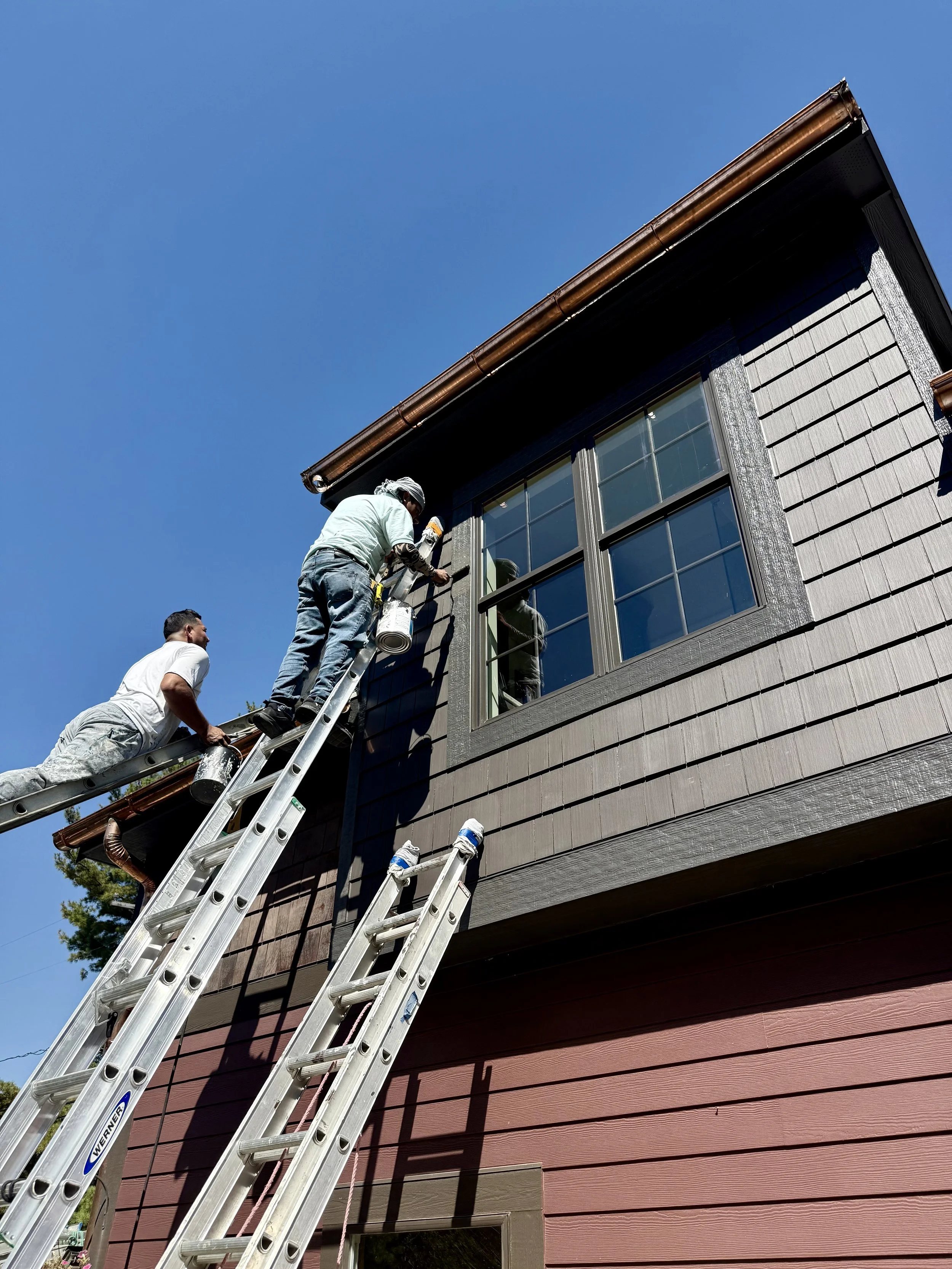 Professional exterior painting crew on ladders painting residential home in Upper Arlington, Ohio.