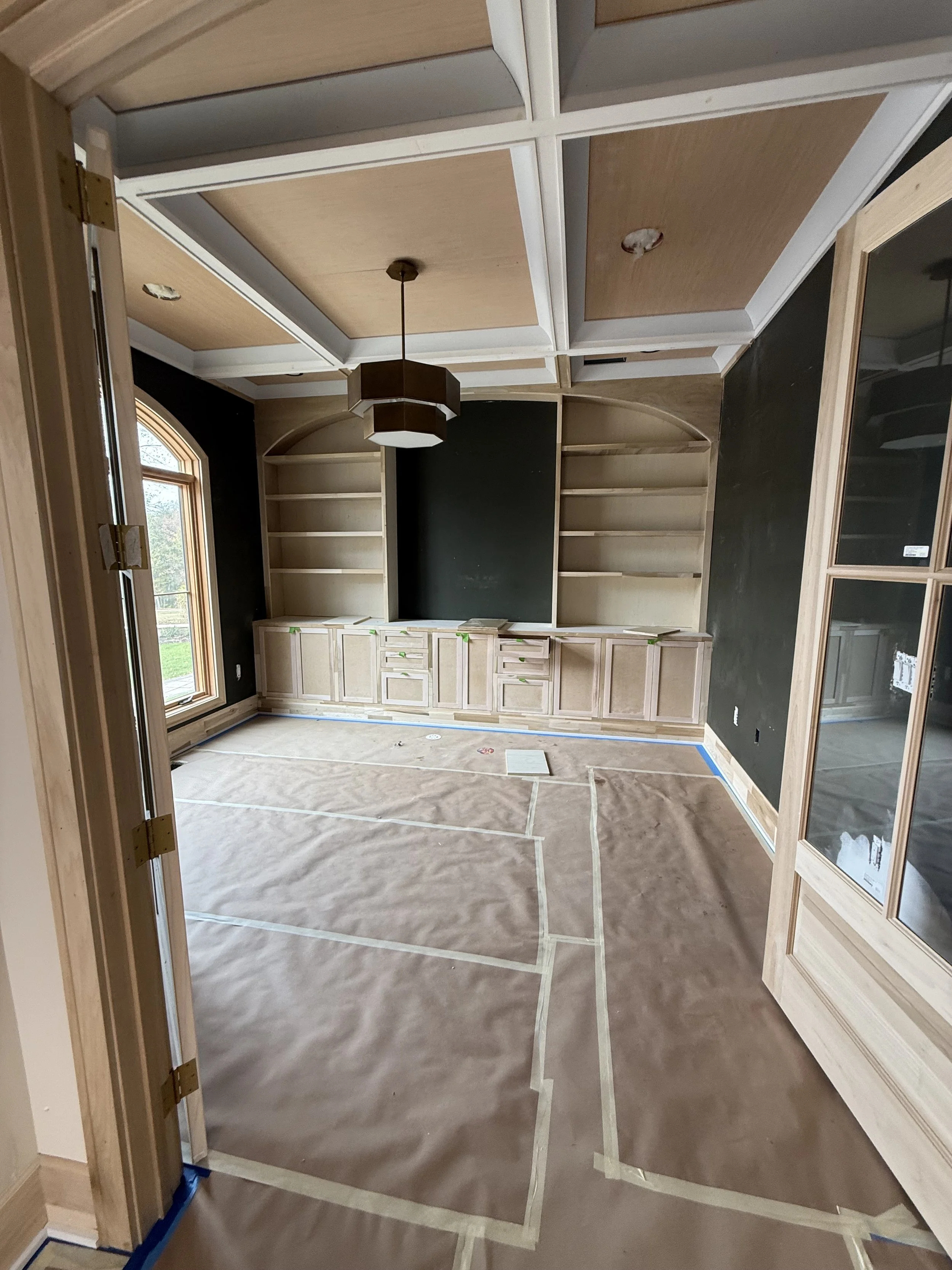 Built-in cabinet painting prep with floor protection and masking during interior residential painting project.