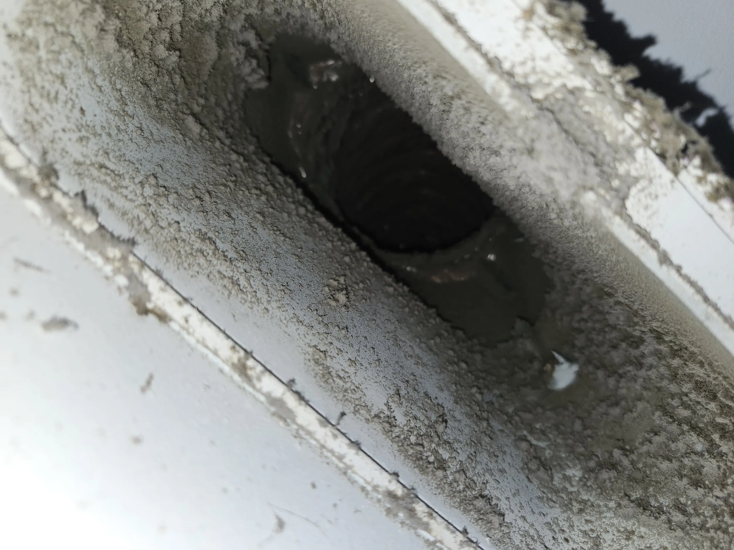 Close-up of a dirty, dusty outdoor air conditioning unit or vent with a hole or opening.