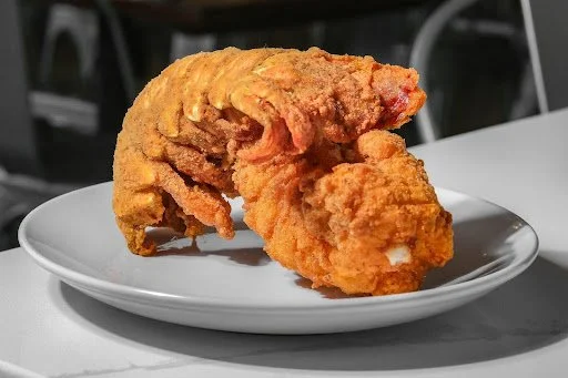 A piece of fried chicken on a white plate