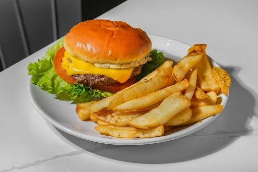 Cheeseburger with lettuce, tomato, cheese, and bun served with French fries on a white plate.