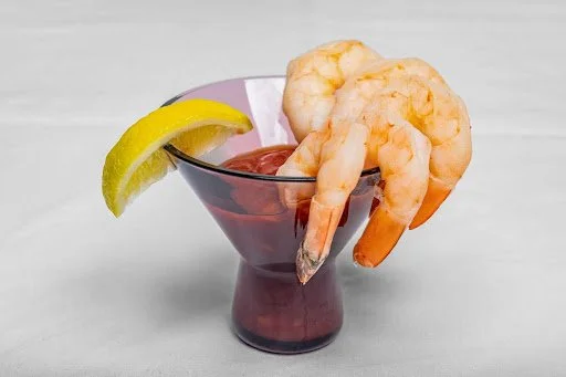 Cocktail glass with shrimp and a lemon wedge