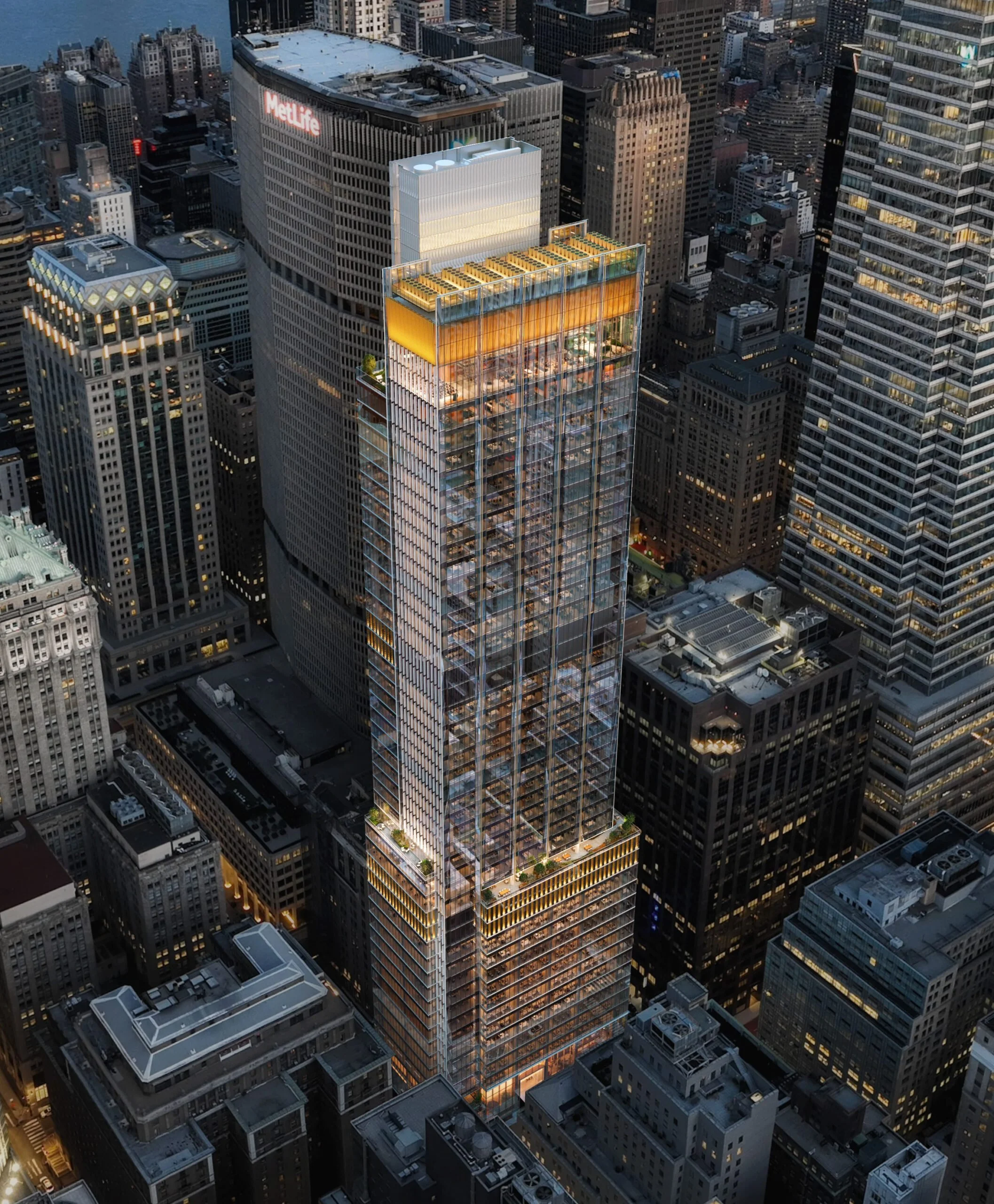 Nighttime aerial view of a skyscraper in a city, with glass exterior and illuminated interior floors, among other tall buildings.