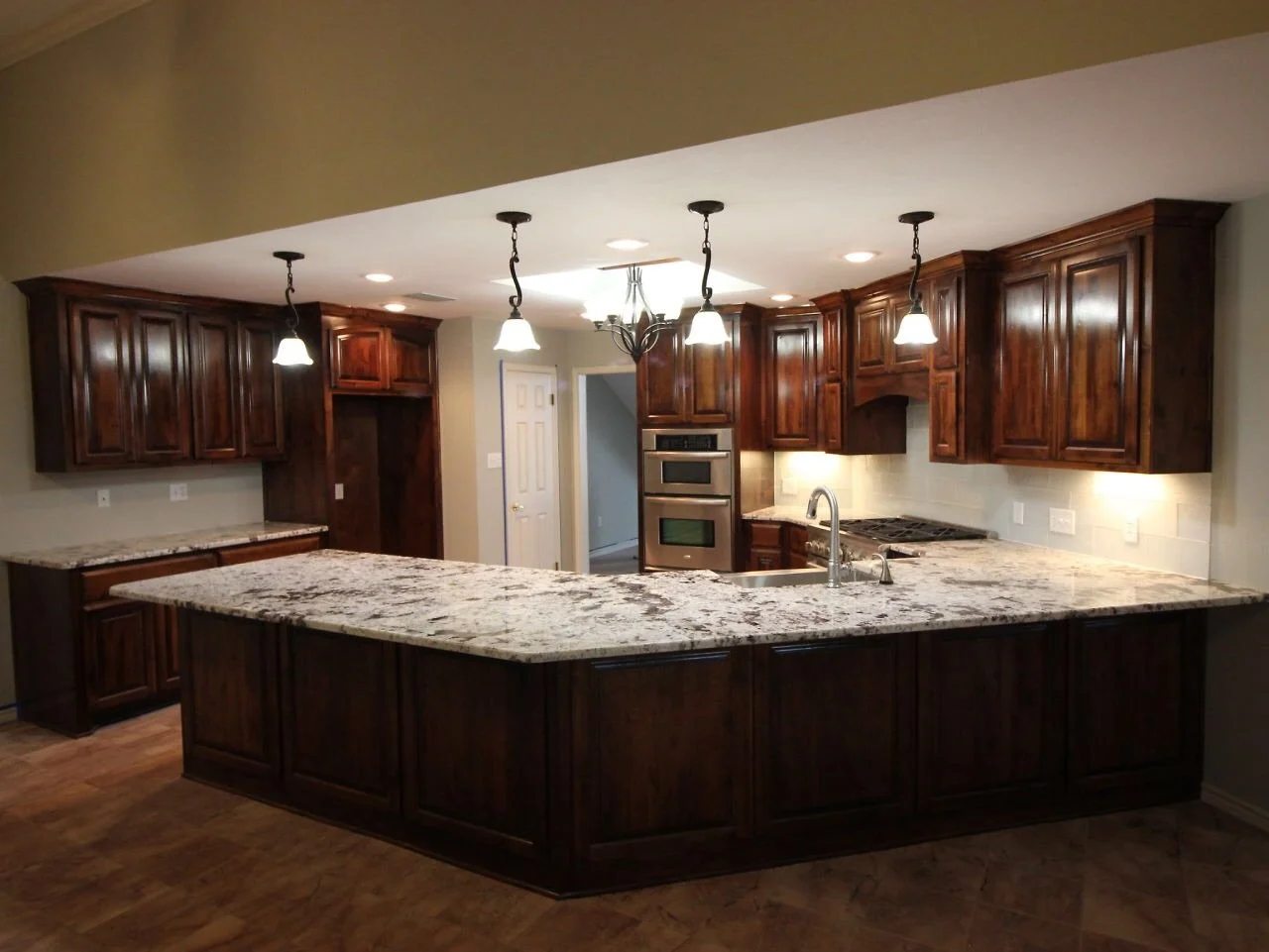 Kitchen with wooden cabinets, granite countertops, and pendant lighting.