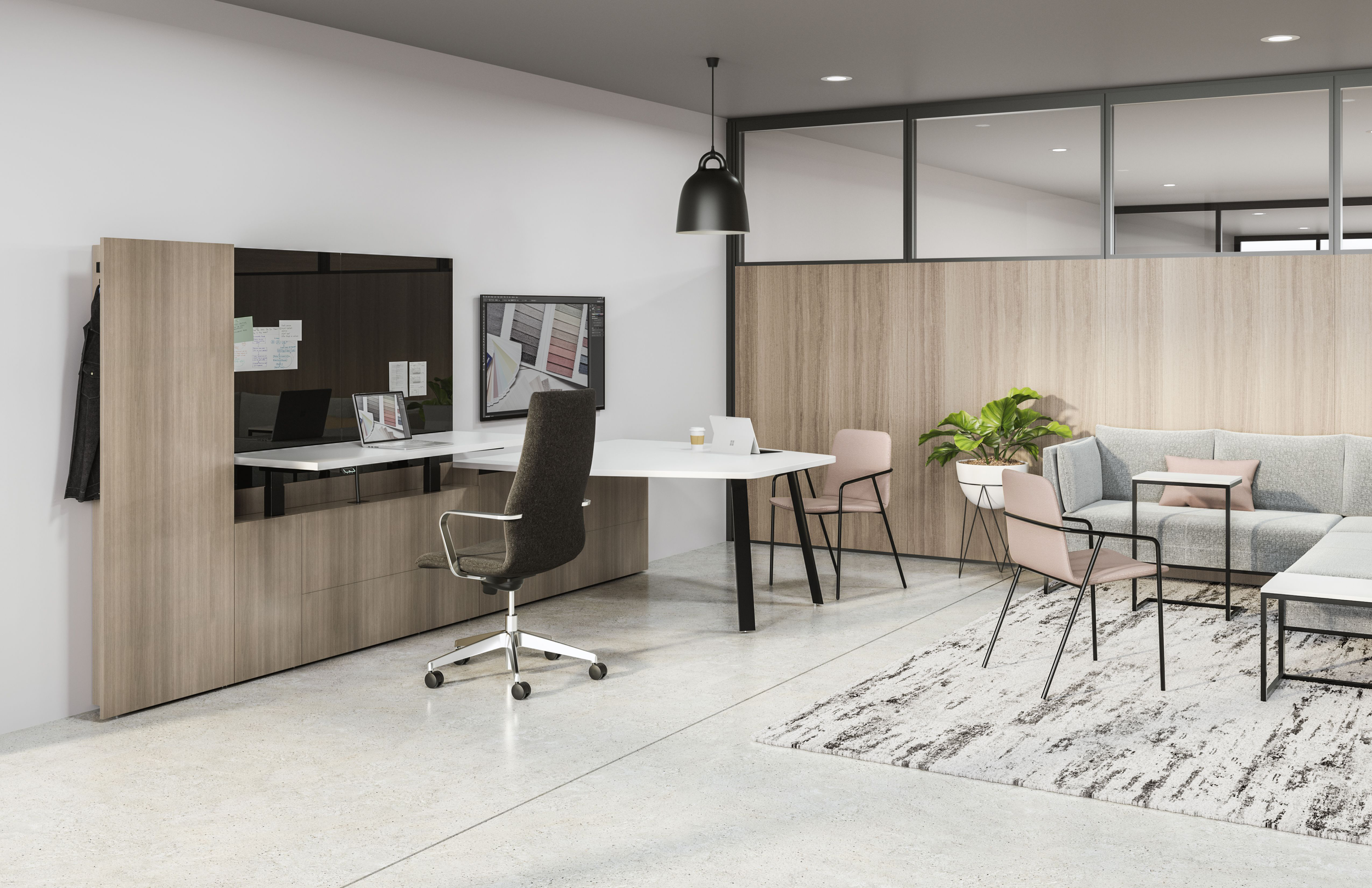 Modern office space with a white desk, ergonomic chair, framed artwork, a sitting area with gray sofa, pink chairs, potted plant, and glass partition walls.