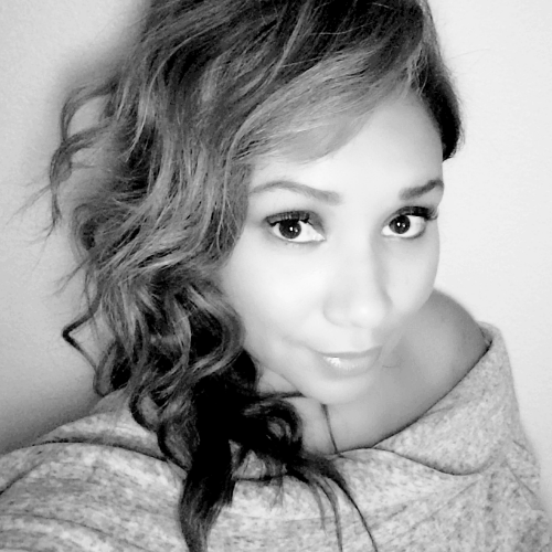Black and white close-up portrait of a woman with wavy hair looking at the camera.