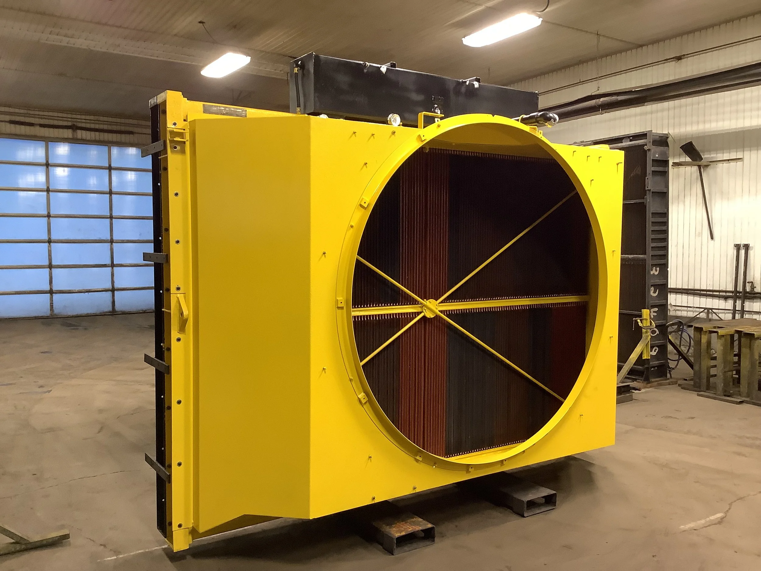 Large yellow industrial fan or cooling system inside a warehouse or factory.