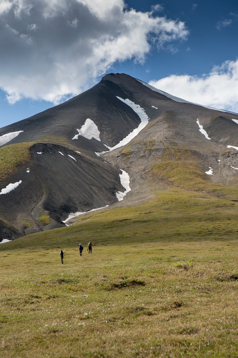 Three hikers crossing tundra toward a Wrangell–St. Elias summit, McCarthy AK.