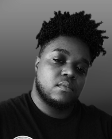 Black and white portrait of a young man wearing a dark shirt against a plain background.