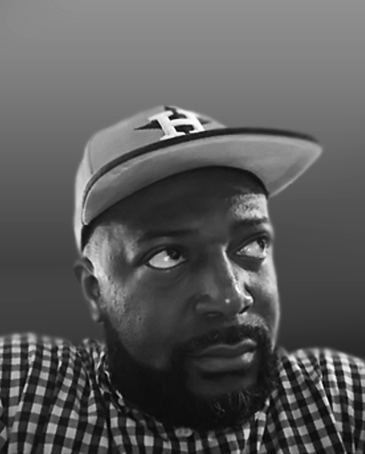 A man wearing a baseball cap and a checkered shirt, looking upwards with a serious expression.
