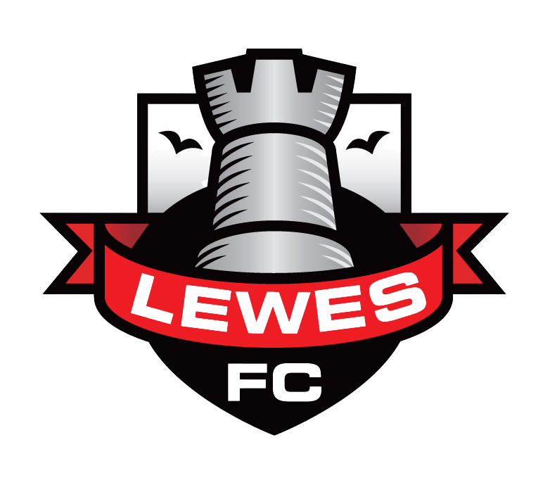 Lewes Football Club (FC) organisation logo. A logo featuring a silver chess rook with a crown on top, a red banner with the name 'LEWES' written on it, and a dark background.
