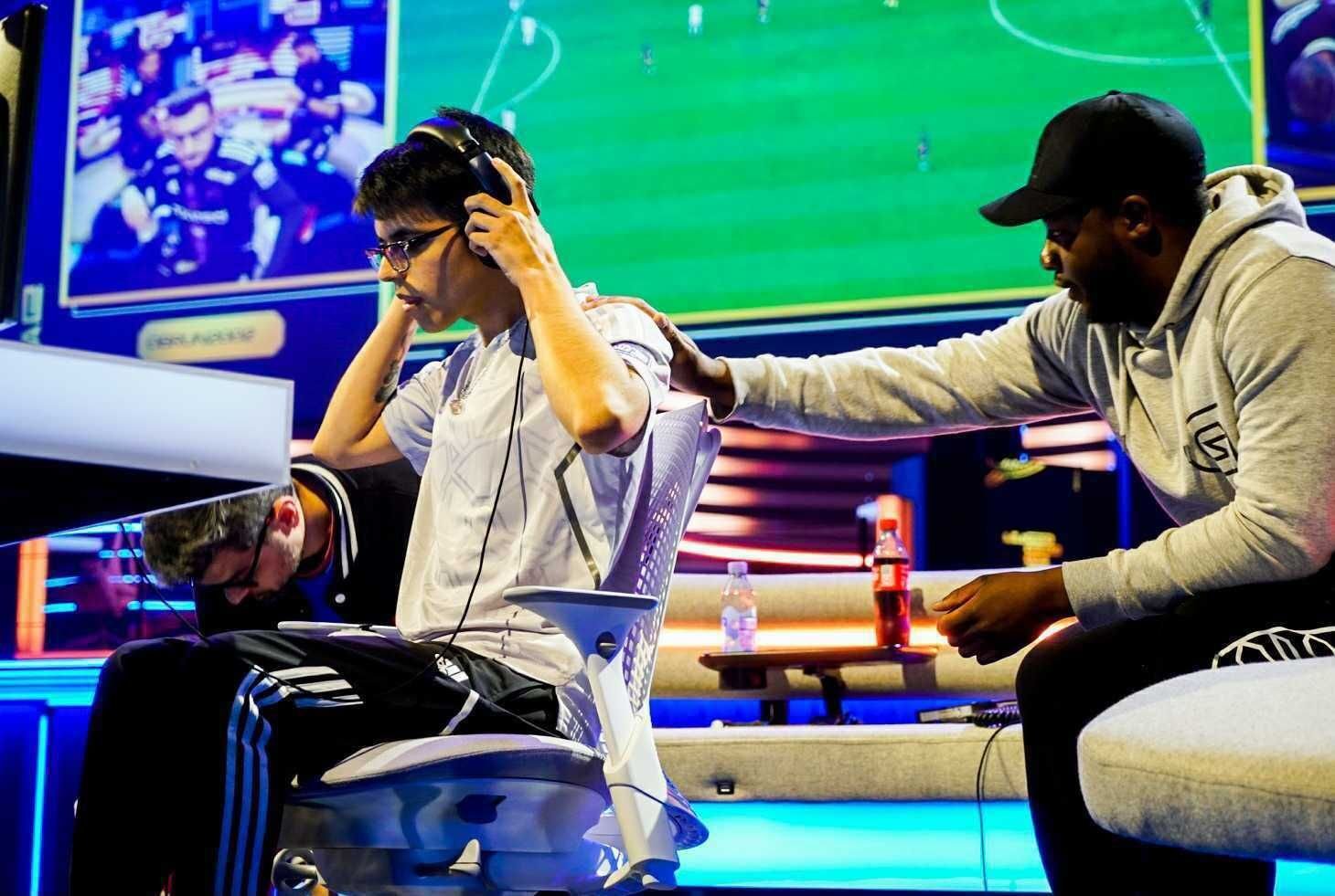 Performance psychologist resting his hand on an athletes shoulder during a competition