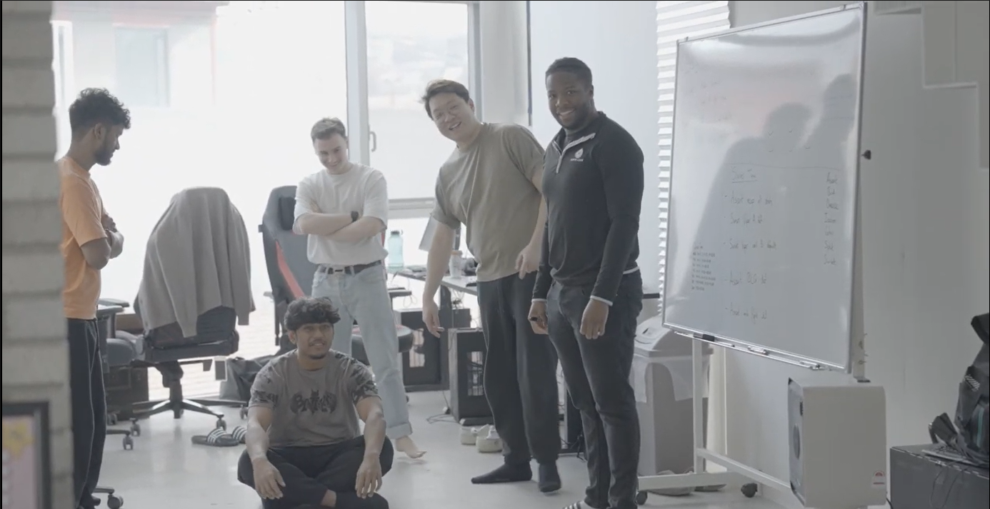 A group of 4 people in a team building exercise smiling and looking at their competition