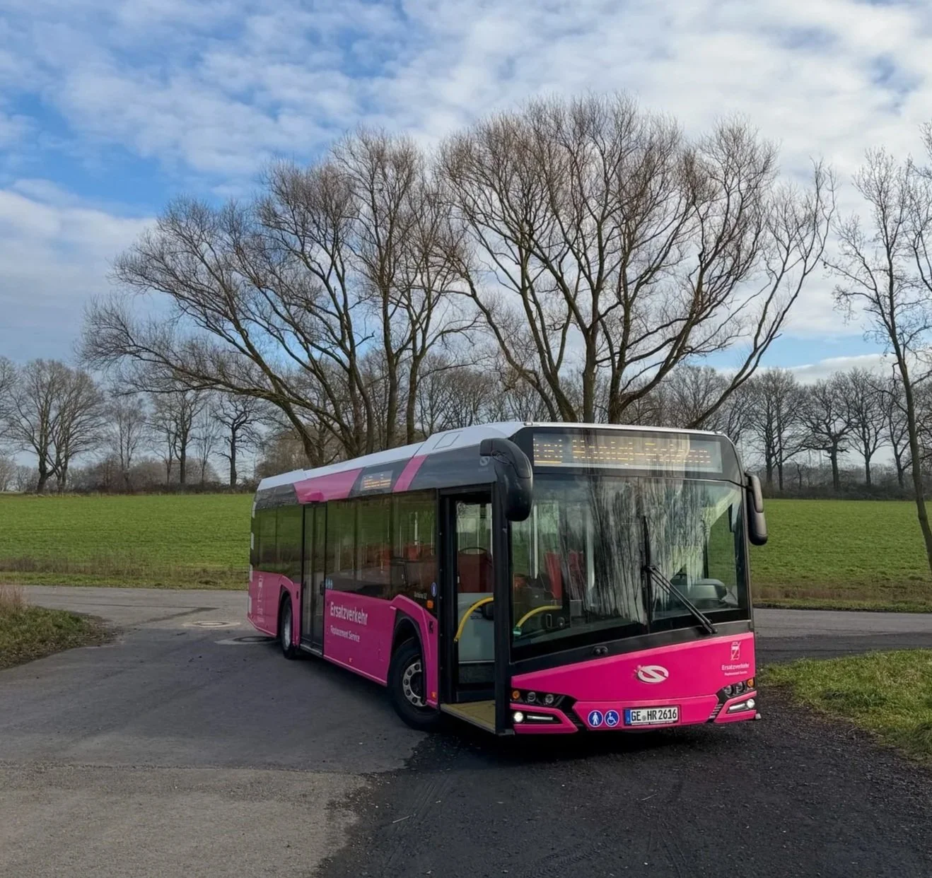 Ein Bus von Haniqi Reisen vor Bäumen