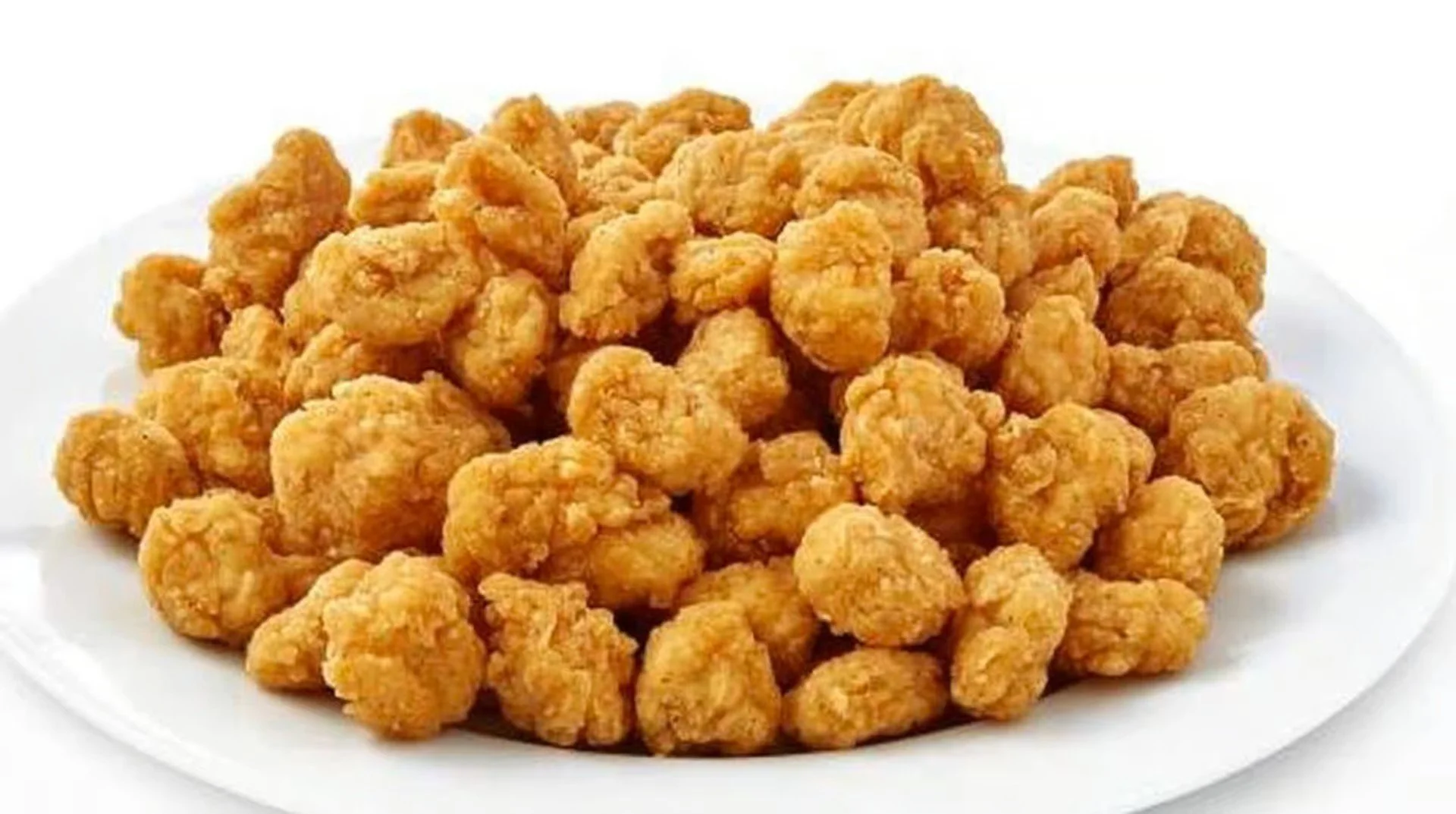 A white plate filled with fried chicken nuggets.