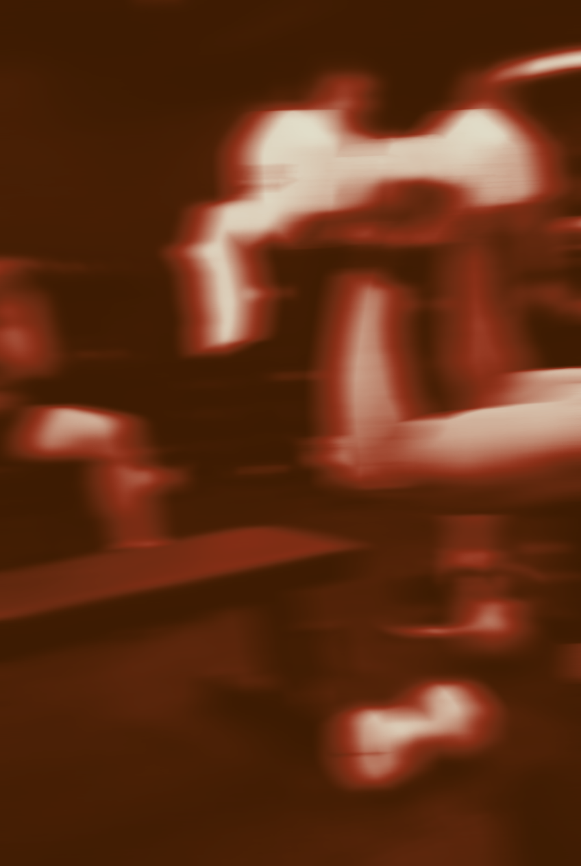 Blurred image with indistinct shapes and motion, appears to be a person in a dark setting with reddish tones.