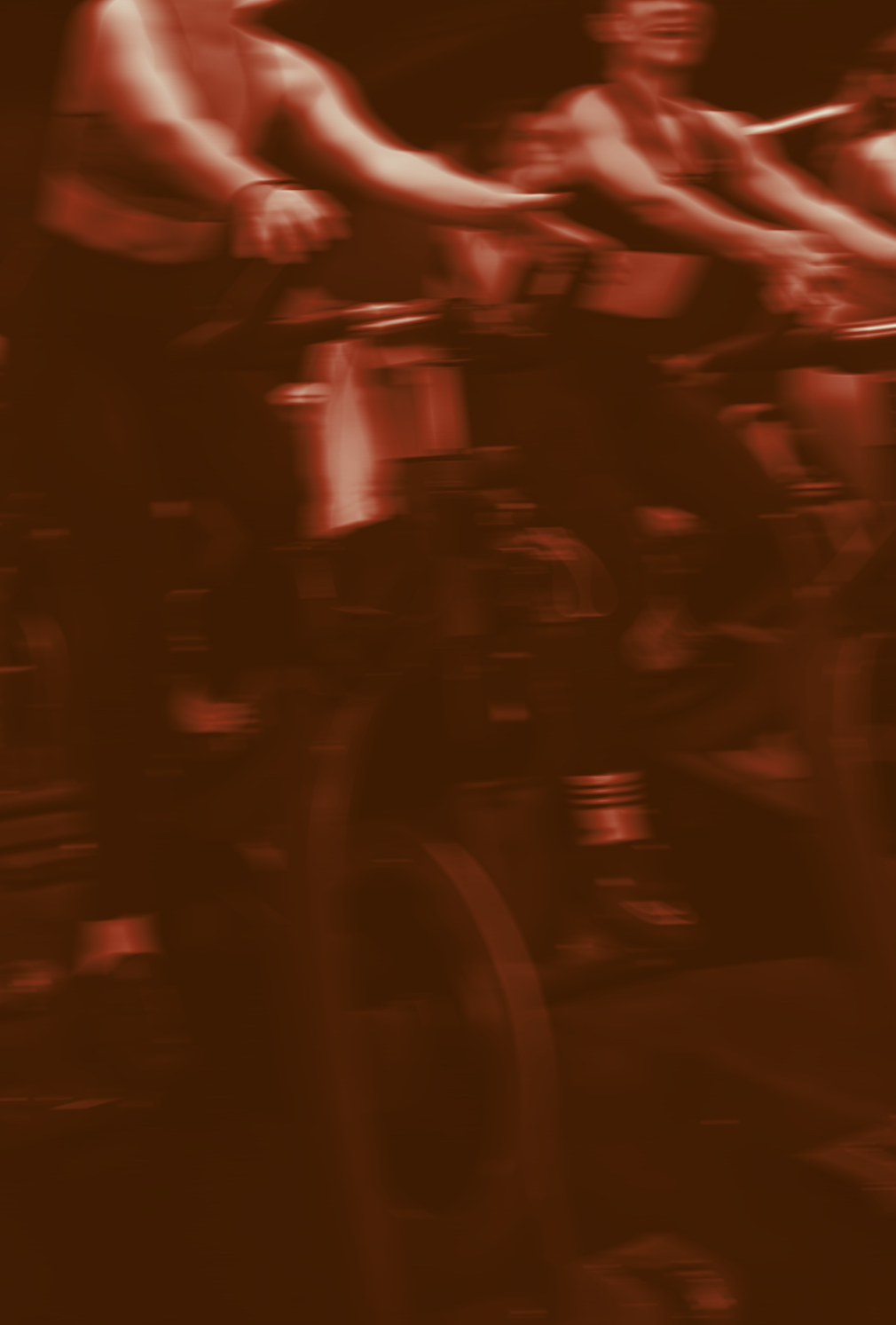 People riding stationary bikes during a cycling class.