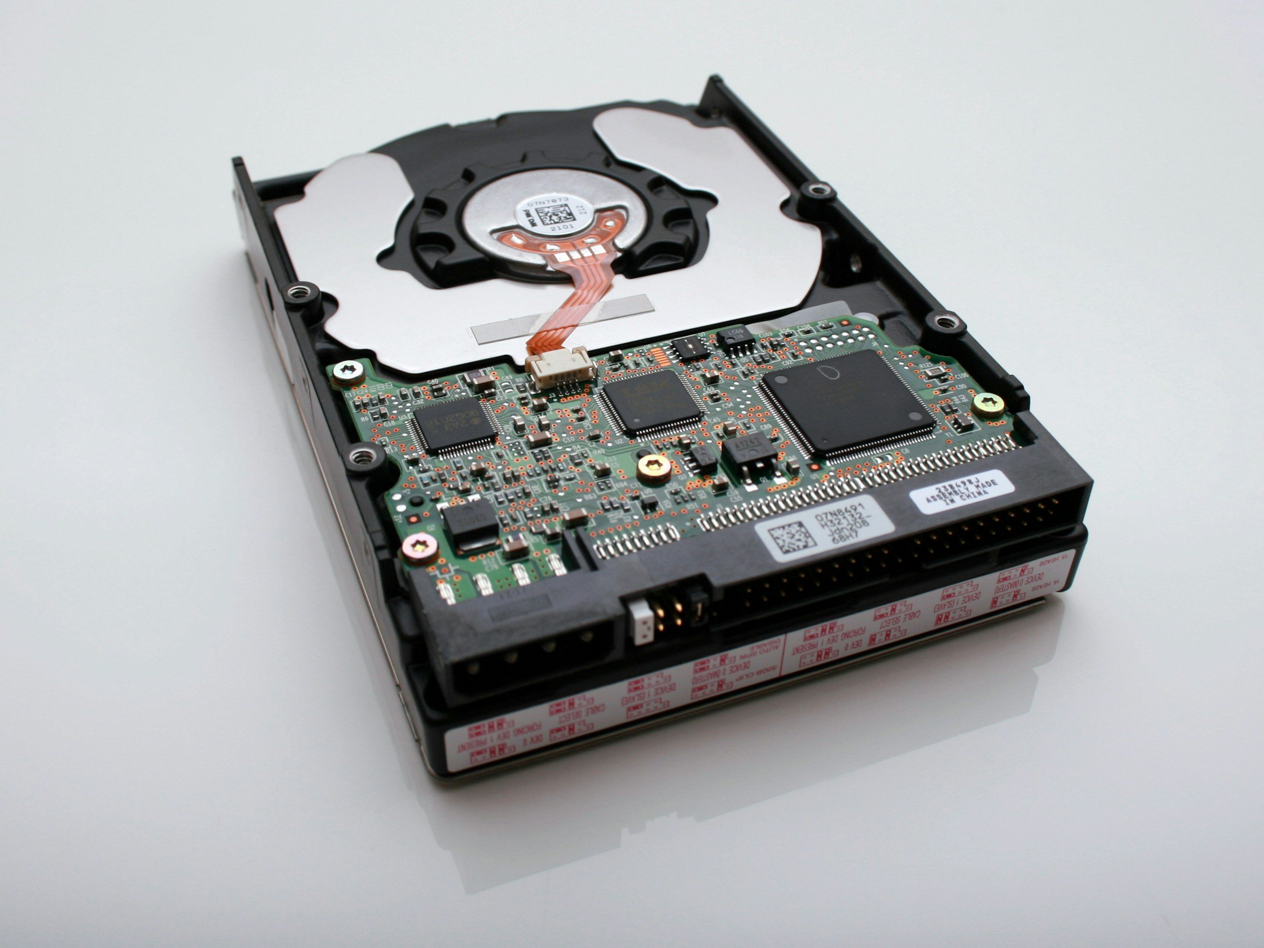Open hard disk drive with visible internal components including platter, spindle, and circuit board.