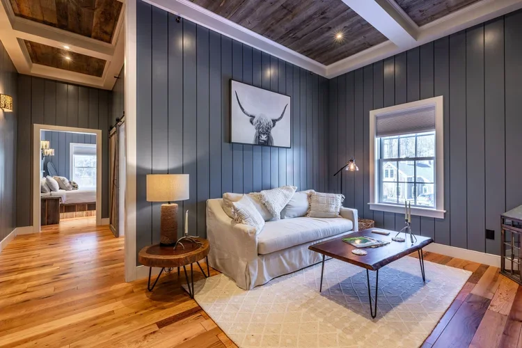 Barnstead Inn suite living area with paneled walls painted dark blue.