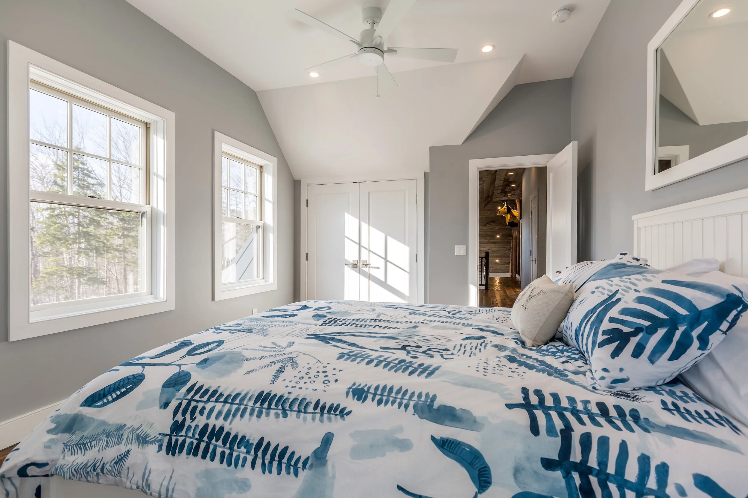 Bedroom with walls painted grey and a bed with blue and white bedding.