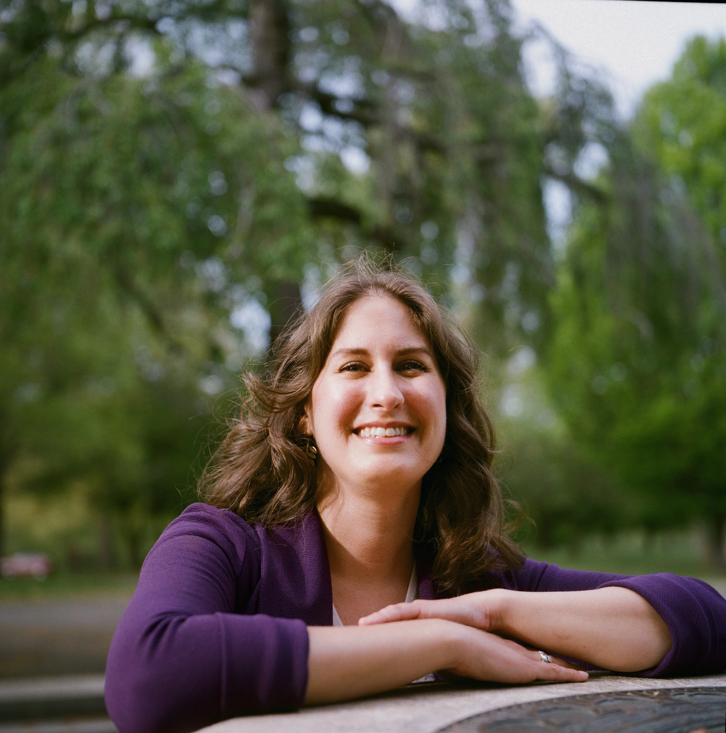 woman smiling with a tree behind her
