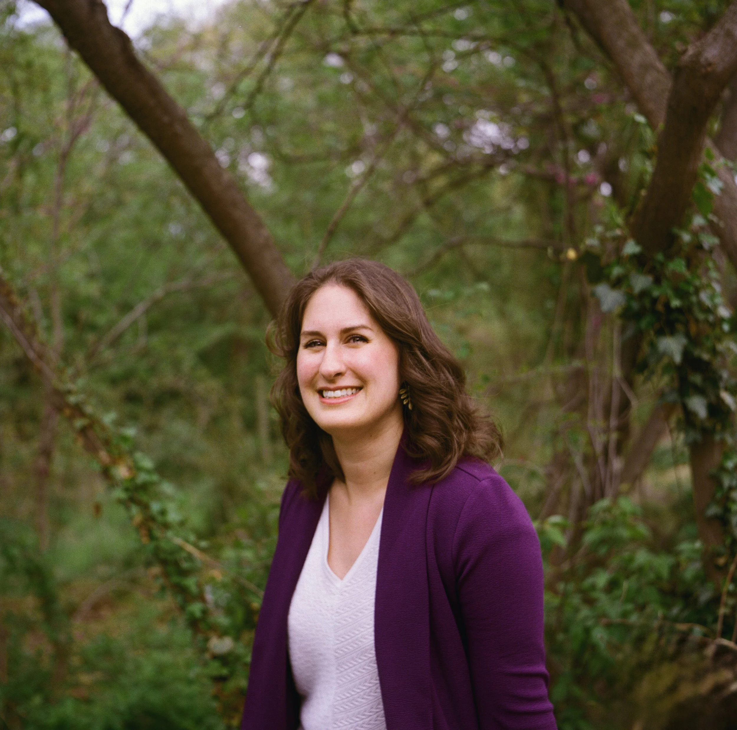woman smiling with a backdrop of trees