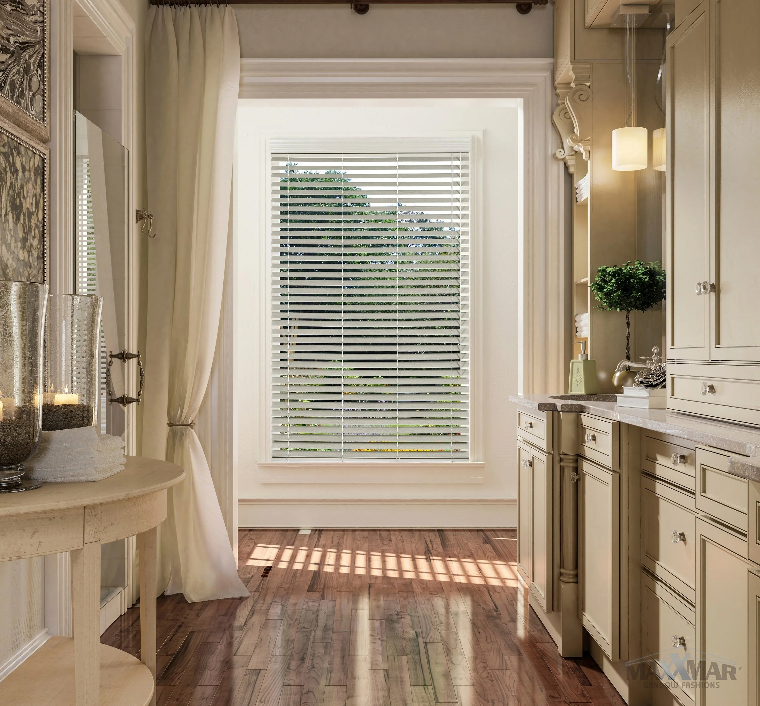 Interior of a well-lit kitchen or dining area with a large window covered by white blinds, cream-colored cabinetry, a countertop with decorative items, and a small plant. The floor is made of polished hardwood, and there are cream curtains and a round table with candles and towels.