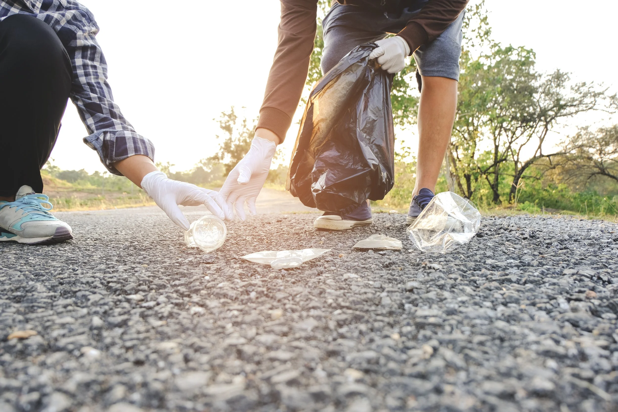 low-section-people-collecting-garbage-road.jpg