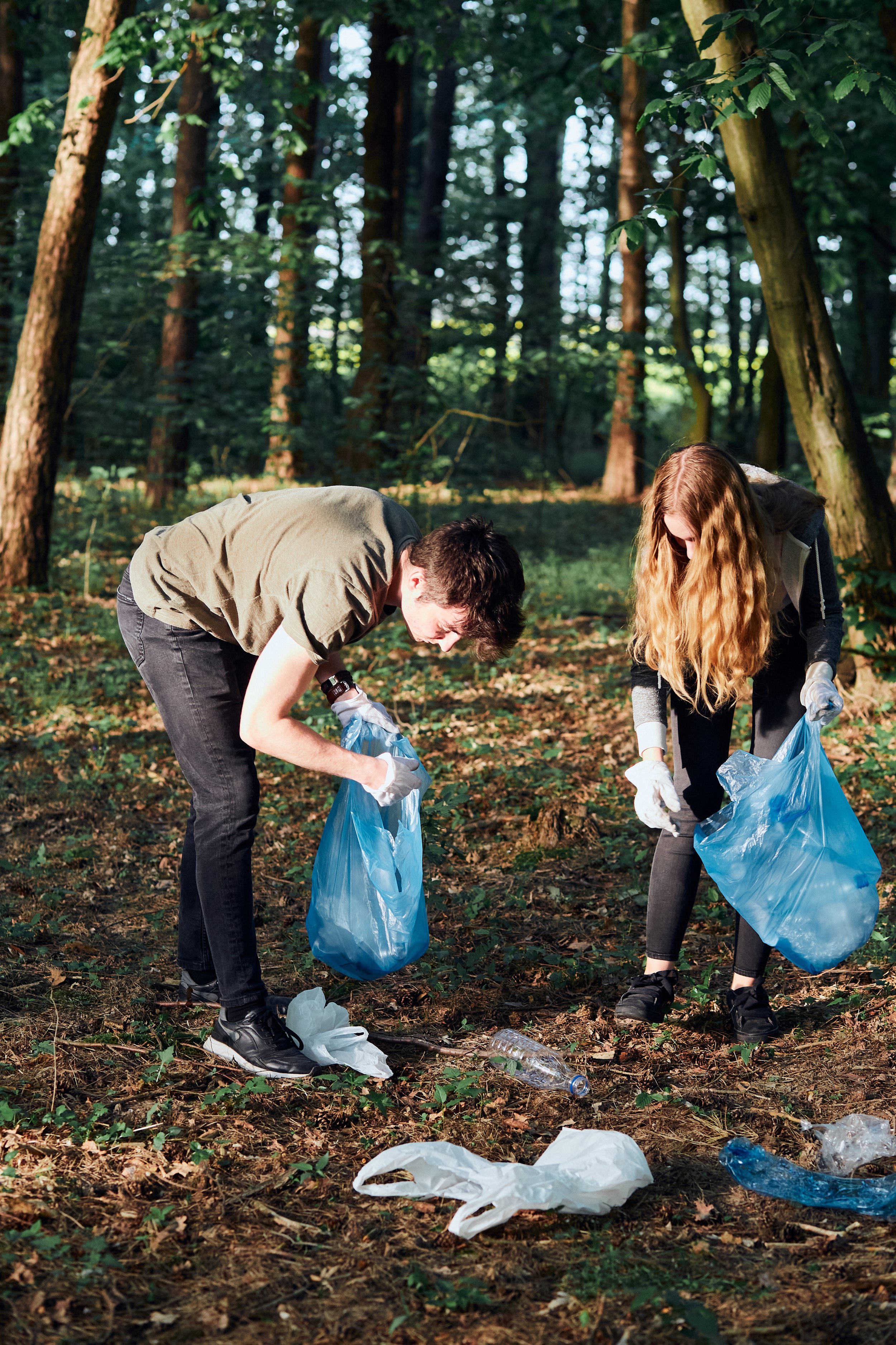 young-man-woman-cleaning-up-forest-volunteers-picking-plastic-waste-bags.jpg