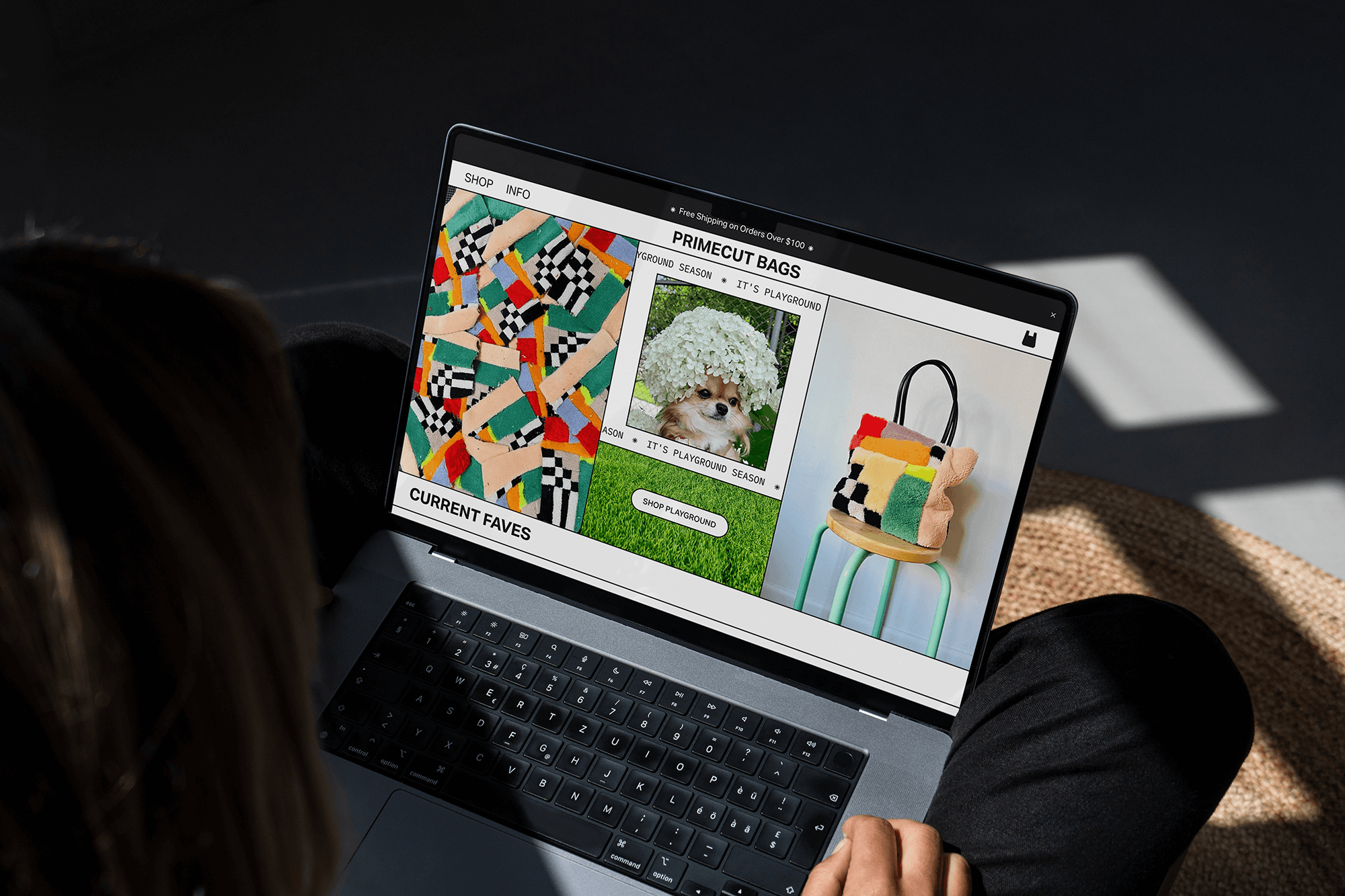Laptop screen displaying an online shop featuring colorful bags and a puppy with a hydrangea flower on its head, outdoors.