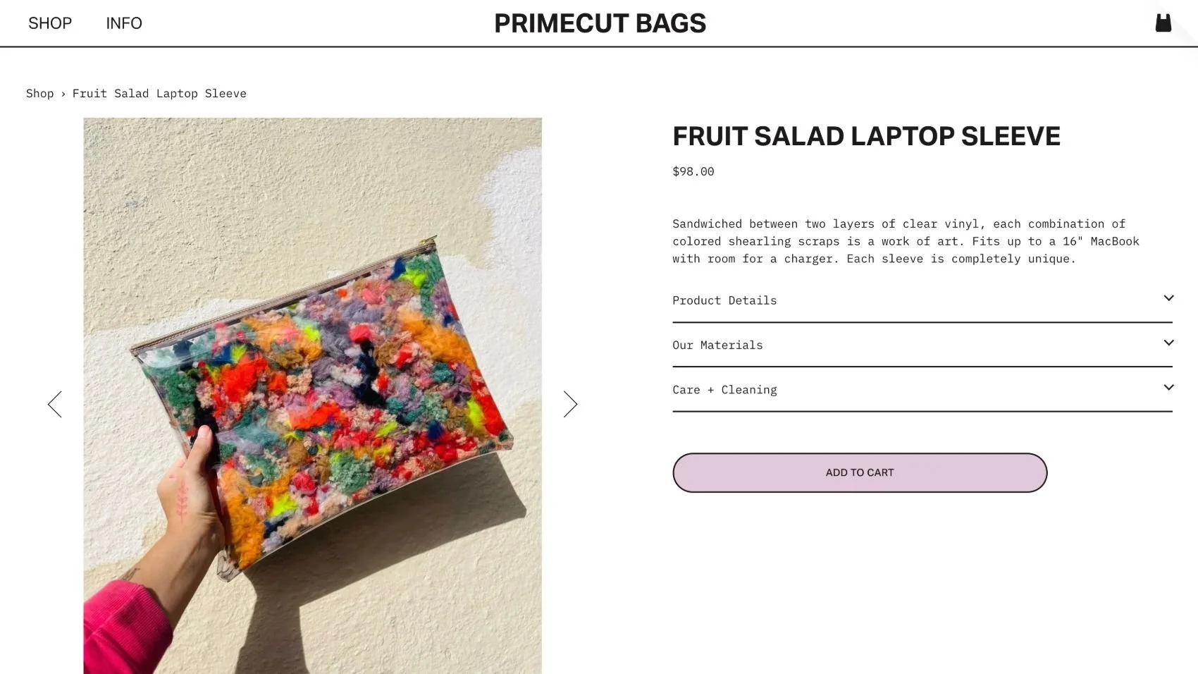 Hand holding a colorful zippered bag filled with multicolored fuzzy pom-poms against a beige textured wall.