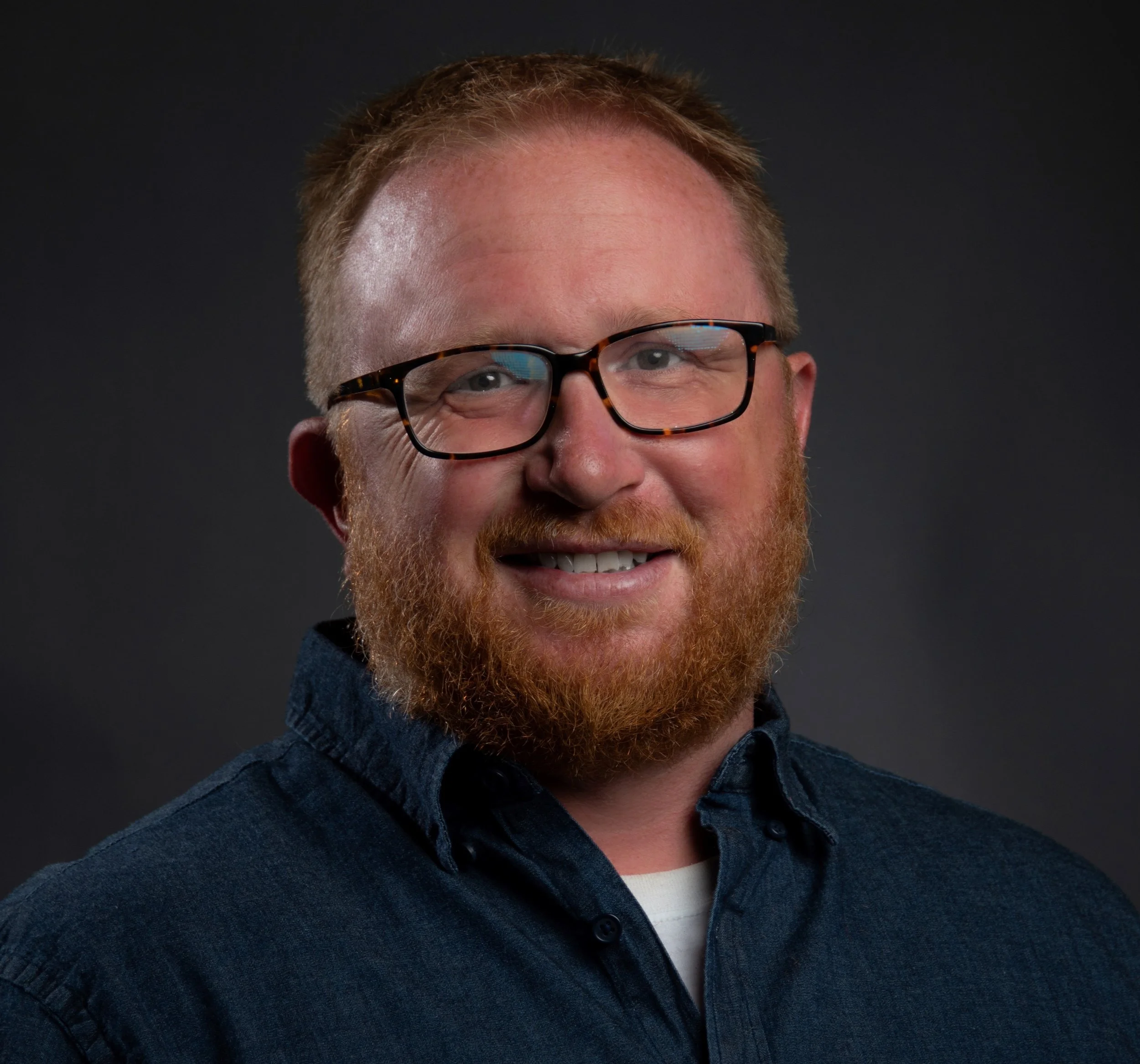 Christian's headshot: a smiling man with red hair and beard and glasses.