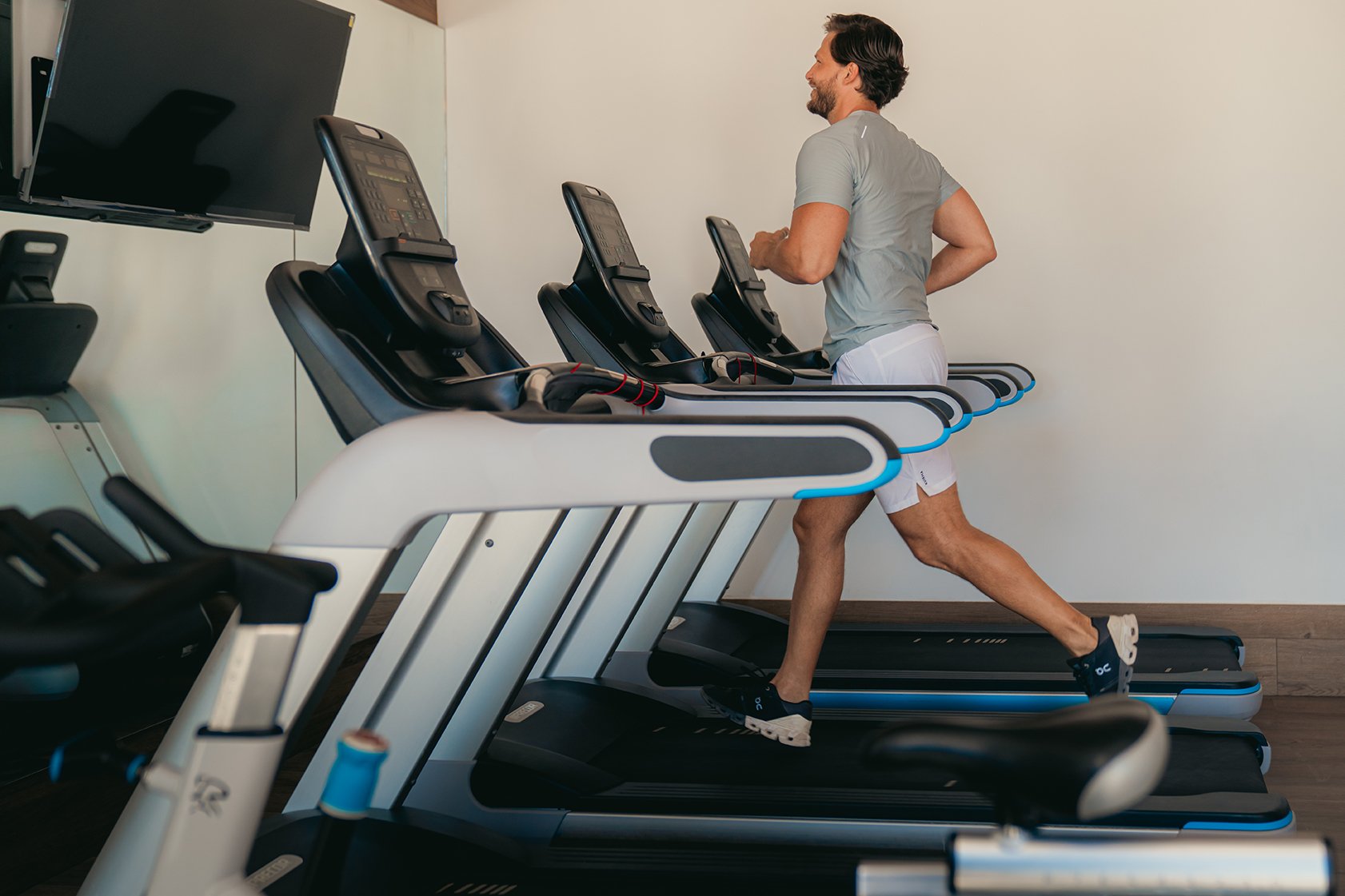 Hombre corriendo en una caminadora en un gimnasio.