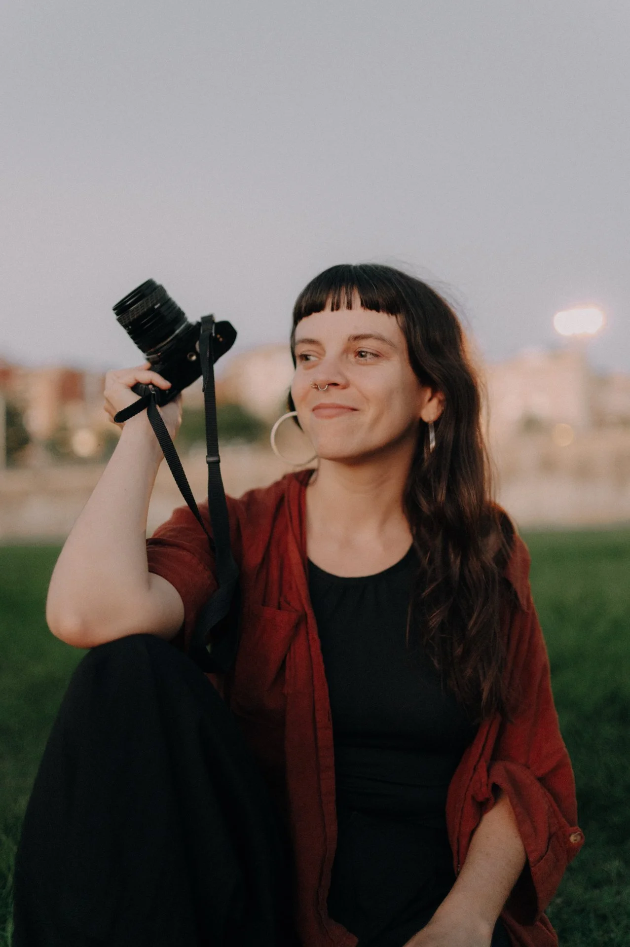 Retrato de la fotógrafa sosteniendo una cámara en la mano.
