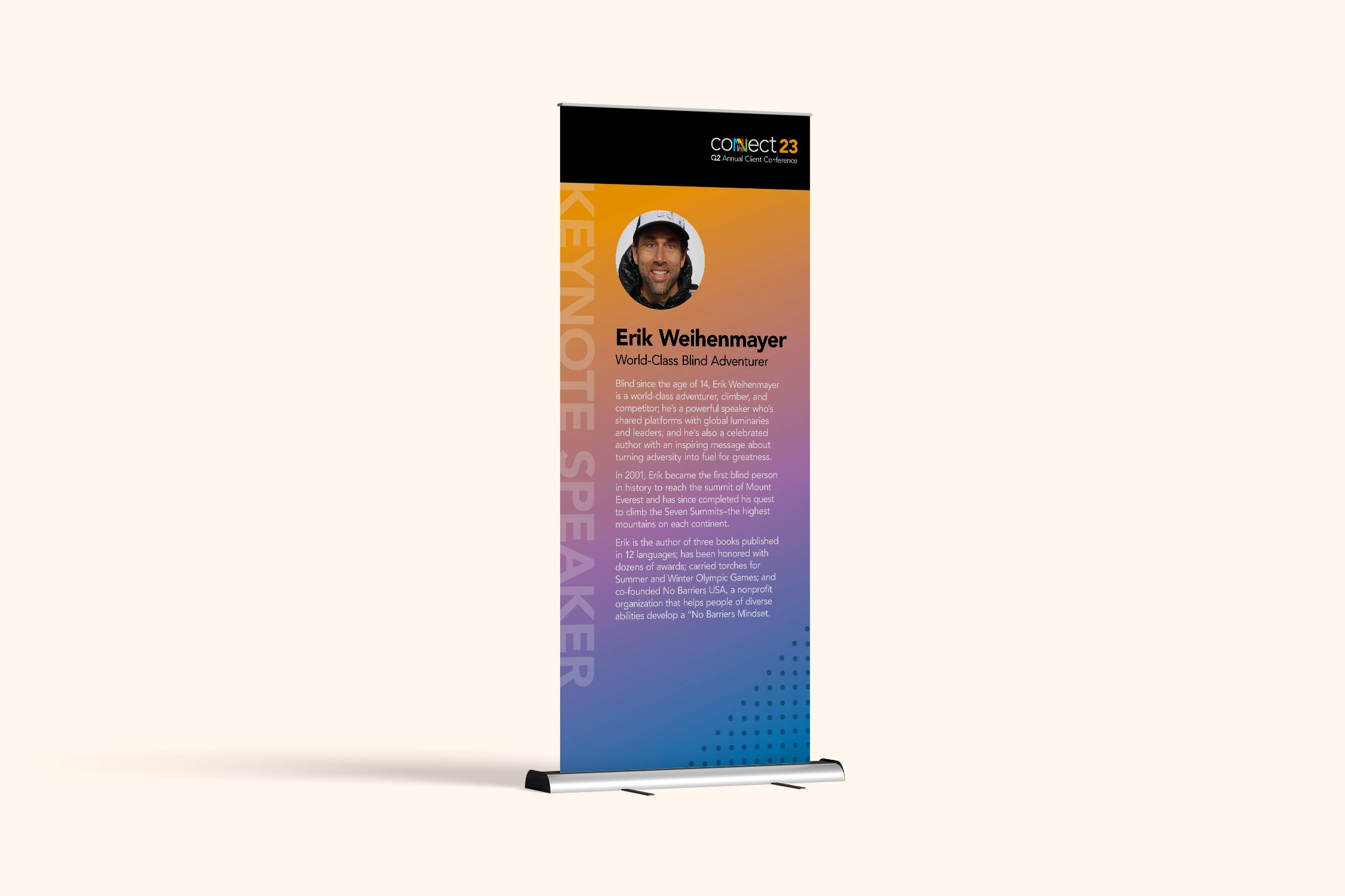 Vertical fabric banner with a rainbow gradient background, featuring a circular photo of a smiling man wearing a helmet. The text introduces Erik Weihenmayer, a blind adventurer and summit climber, explaining his achievements and advocacy.