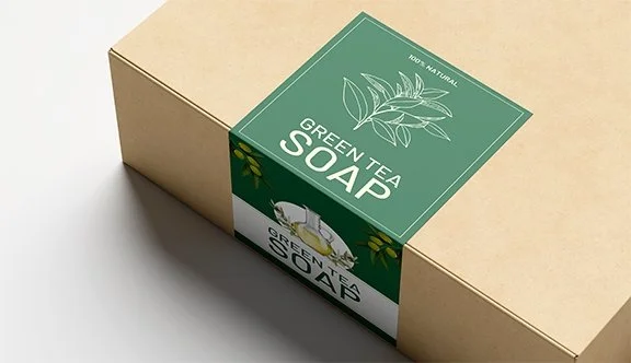 A beige cardboard box with a green label featuring a leaf design and the text 'Green Tea Soap'.