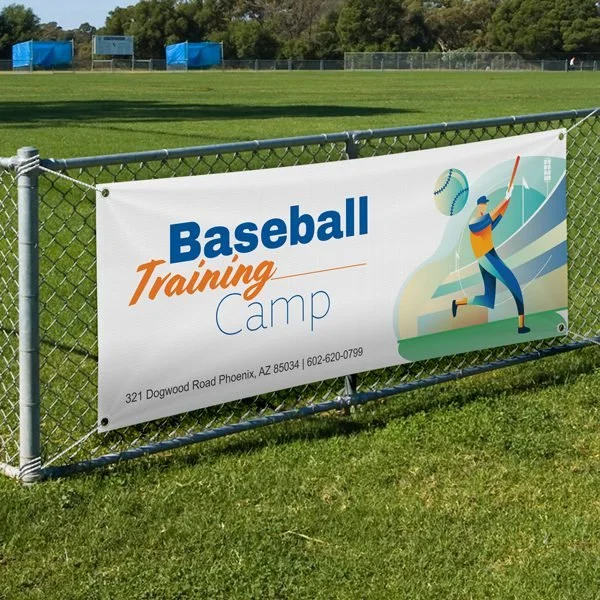 Banner on a chain-link fence advertising a baseball training camp at Dogwood Road in Phoenix, Arizona.