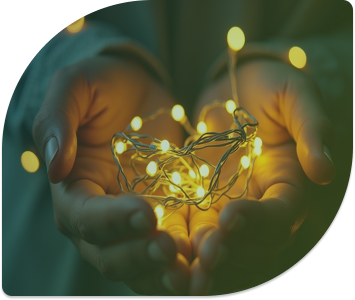 Hands holding a bundle of glowing yellow fairy lights.